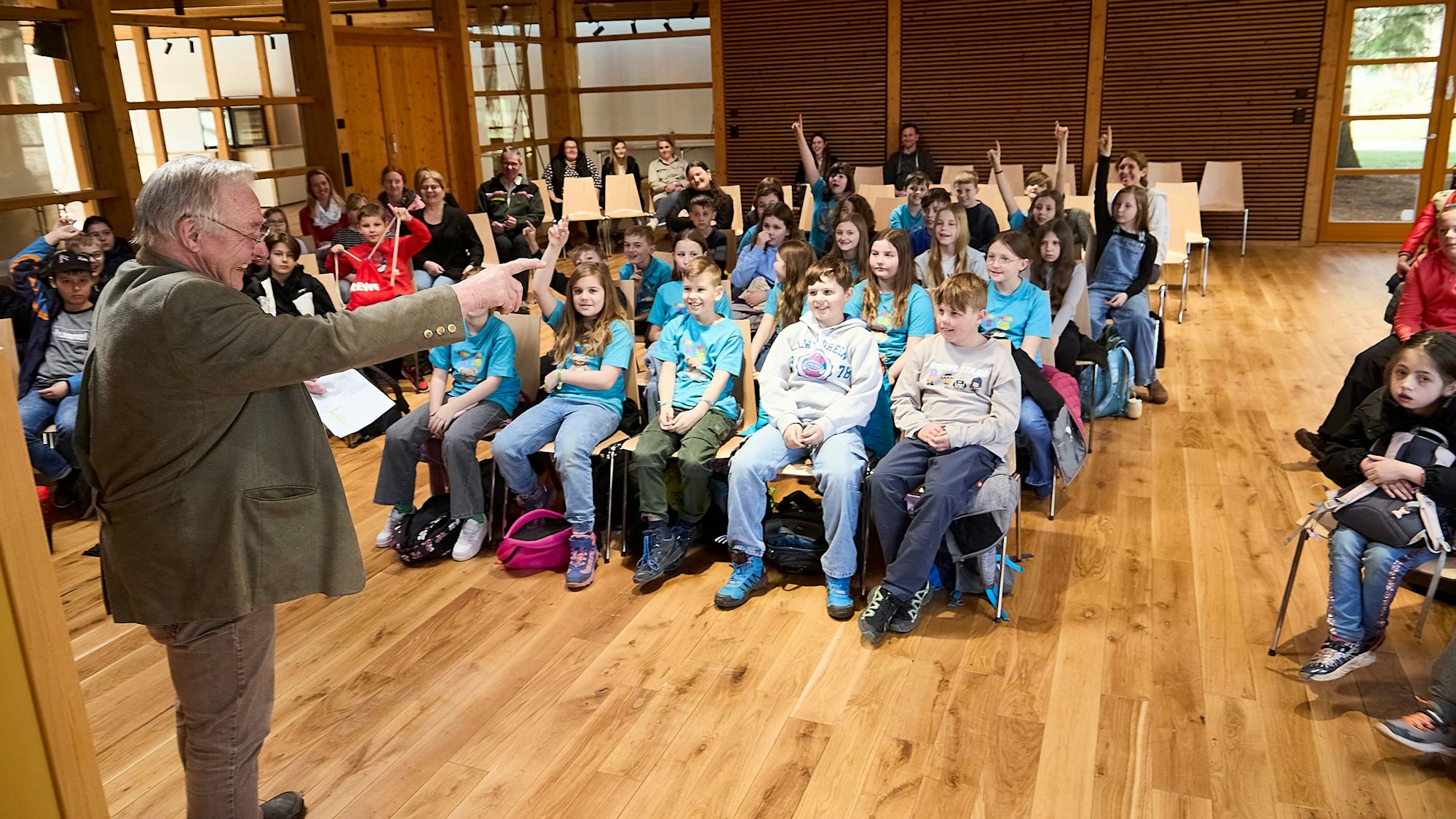 Clemens Pick begrüßt die Kinder in den Stuhlreihen.