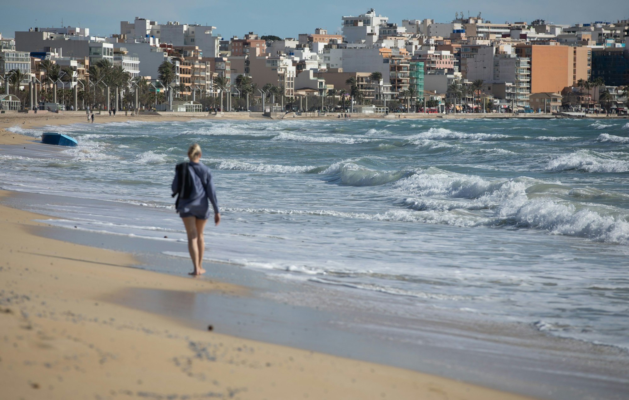 Eine Frau spaziert an einem windigen Tag am Strand von Arenal auf Mallorca entlang. In einigen Fällen wurden die Leichen von Passanten entdeckt. (Archivbild)