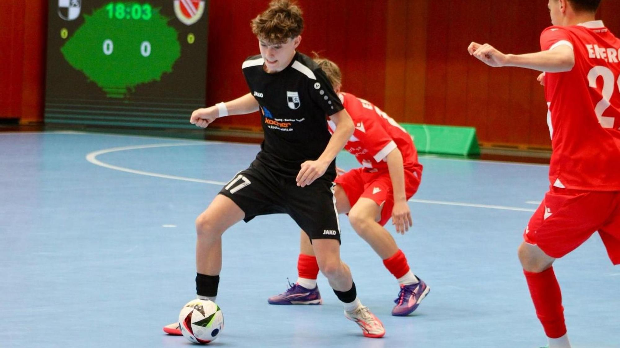 Rafael Baum mit dem Ball am Fuß wird von zwei Cottbuser Spielern angegriffen.
