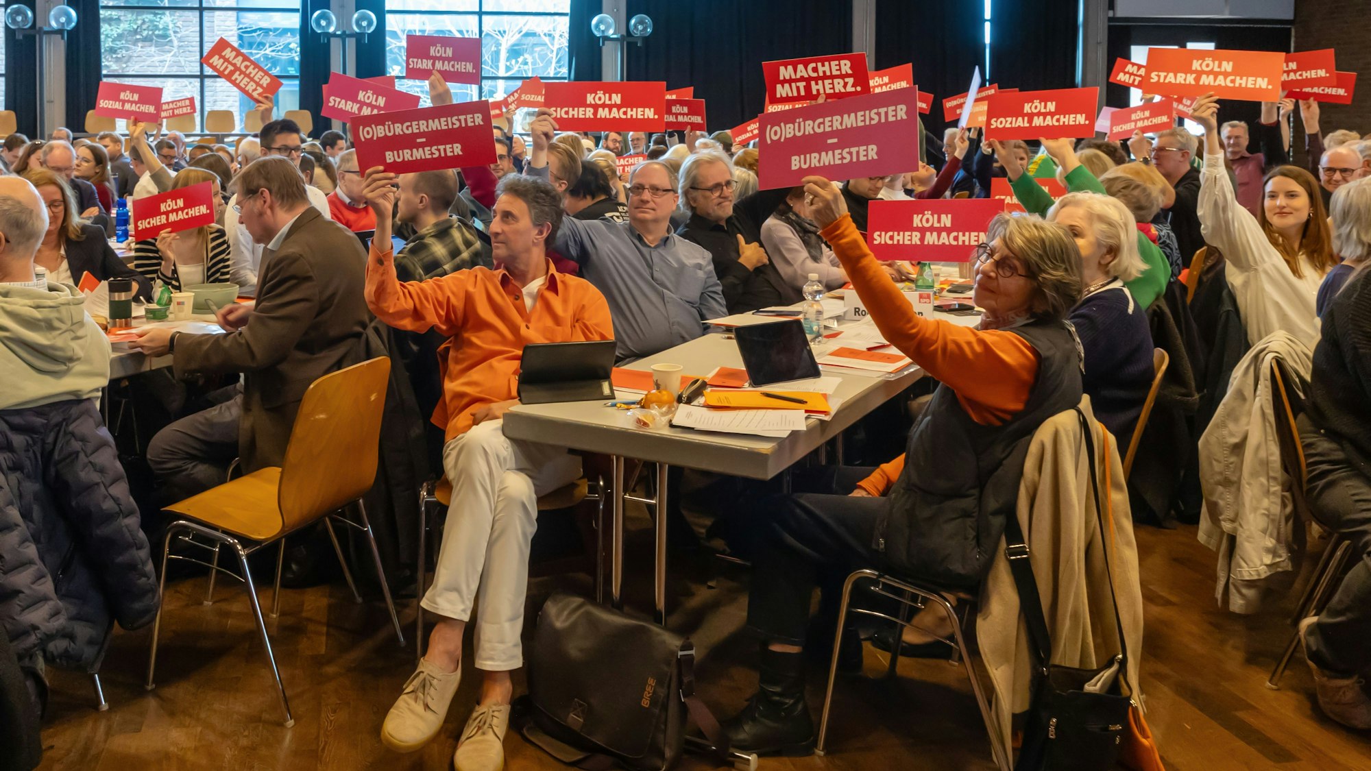 Die SPD-Delegierten halten Schilder hoch mit den Mantras ihres OB-Kandidaten Torsten Burmester für den anstehenden Kommunalwahlkampf.