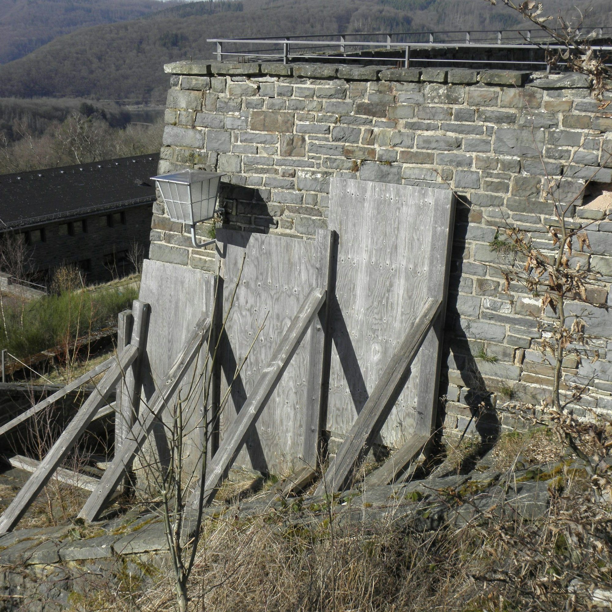 Eine Terrasse wird durch Holzbalken abgestützt.