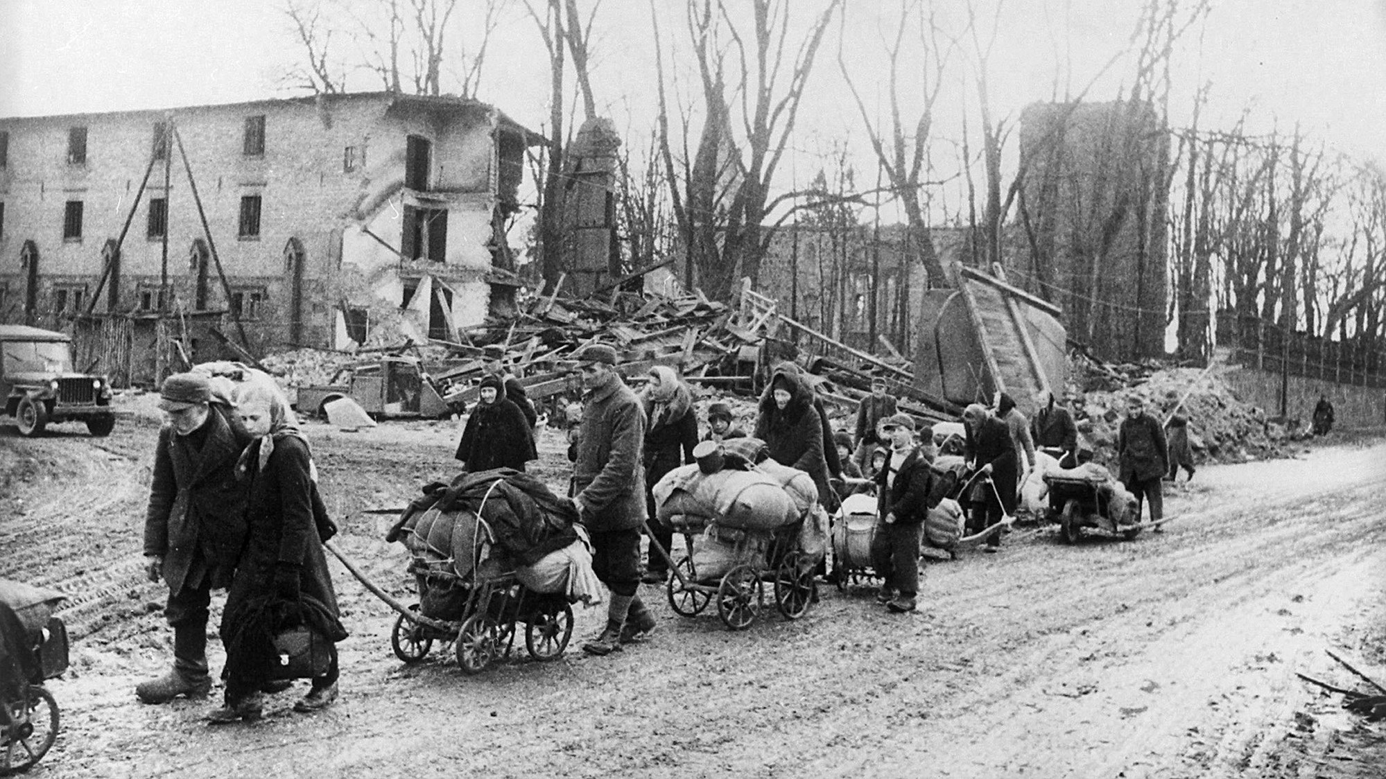 Ein Flüchtlingstreck, viele Menschen mit ihren Habseligkeiten auf Handwagen