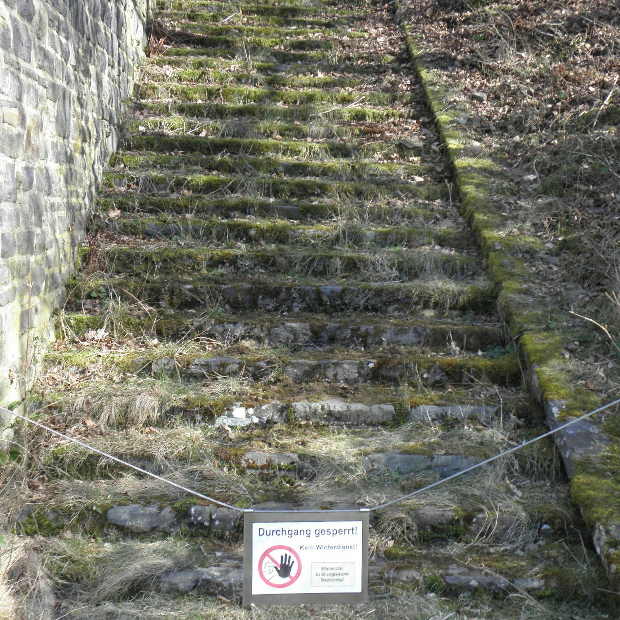 Ein Schild mit der Aufschrift "Durchgang gesperrt" an der Treppe zu einem Hundertschaftshaus.
