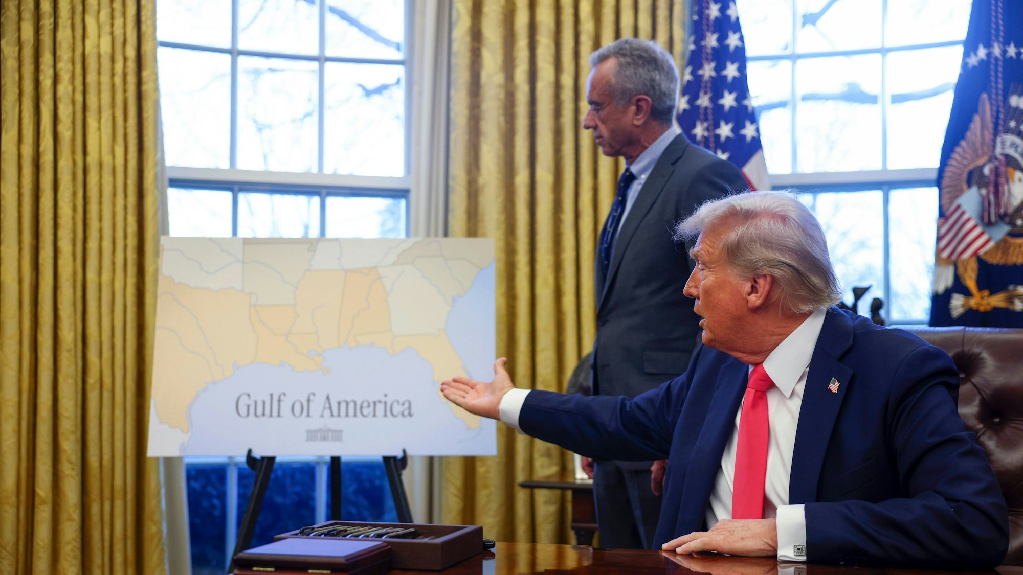 US-Präsident Donald Trump deutet auf ein Plakat mit der Aufschrift ´Gulf of America» (´Golf von Amerika»), während der Minister für Gesundheit und Soziales, Robert F. Kennedy Jr., im Oval Office des Weißen Hauses zusieht.