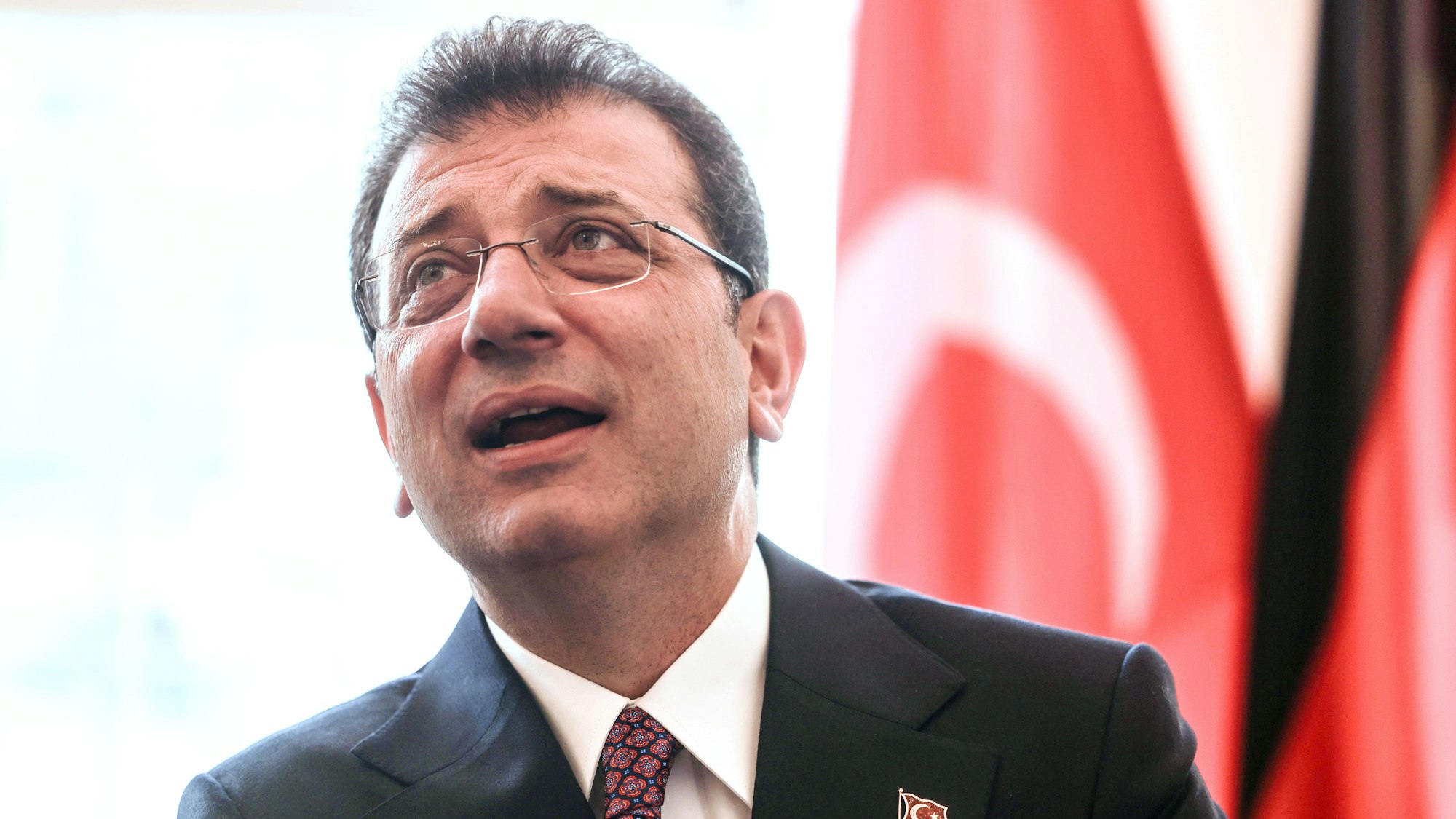 ARCHIV - 20.06.2024, Nordrhein-Westfalen, Düsseldorf: Ekrem Imamoglu, Oberbürgermeister von Istanbul, steht bei einem Empfang im Rathaus vor einer türkischen Fahne. (zu dpa: «Erdogan-Rivale muss in U-Haft · mehr Proteste erwartet») Foto: Oliver Berg/dpa +++ dpa-Bildfunk +++