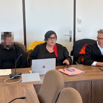Zwei der Angklagten mit den Verteidigern Karin Bölter und Sebastian Schölzel beim Prozessauftakt im Landgericht Köln