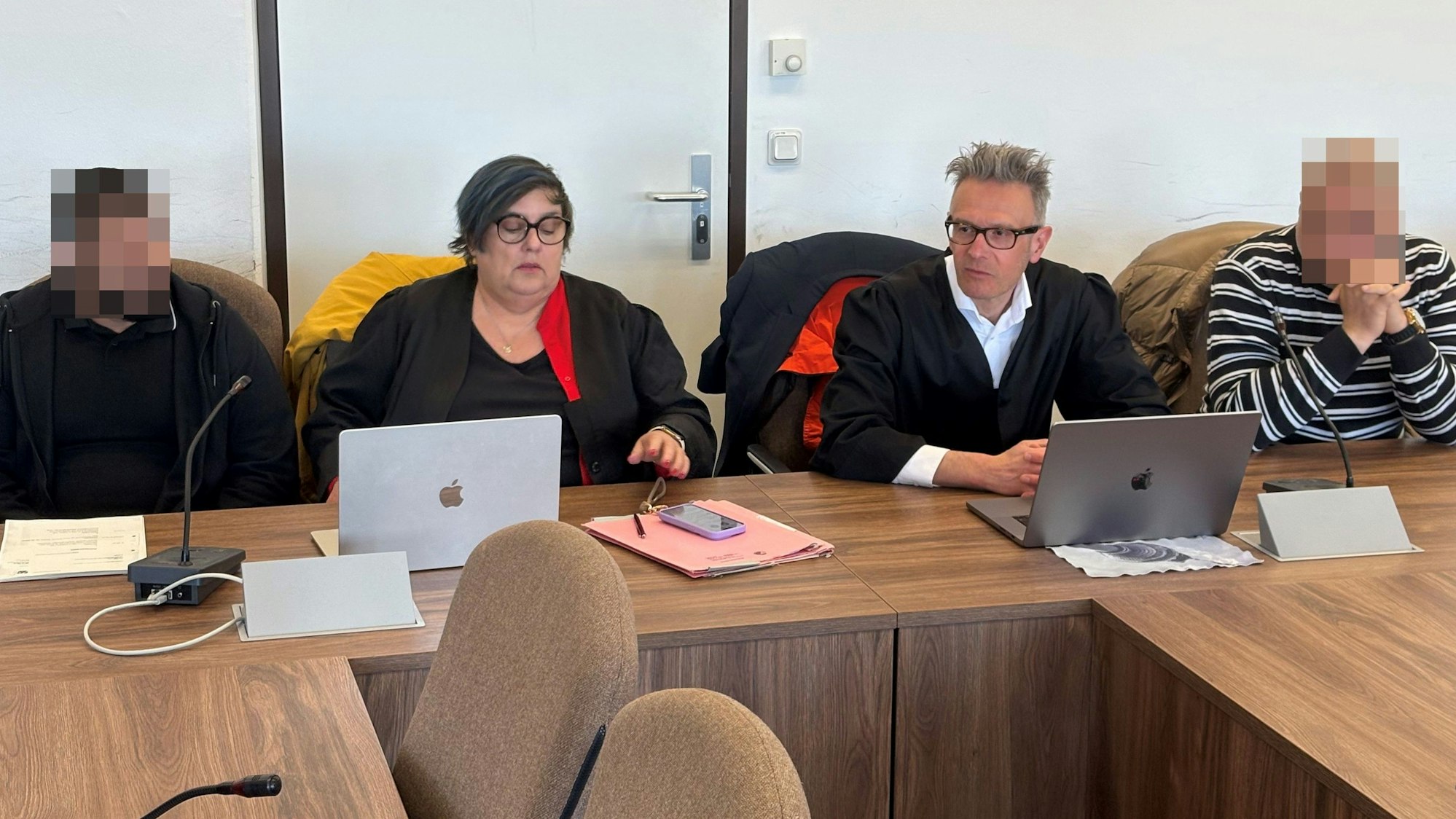 Zwei der Angklagten mit den Verteidigern Karin Bölter und Sebastian Schölzel beim Prozessauftakt im Landgericht Köln