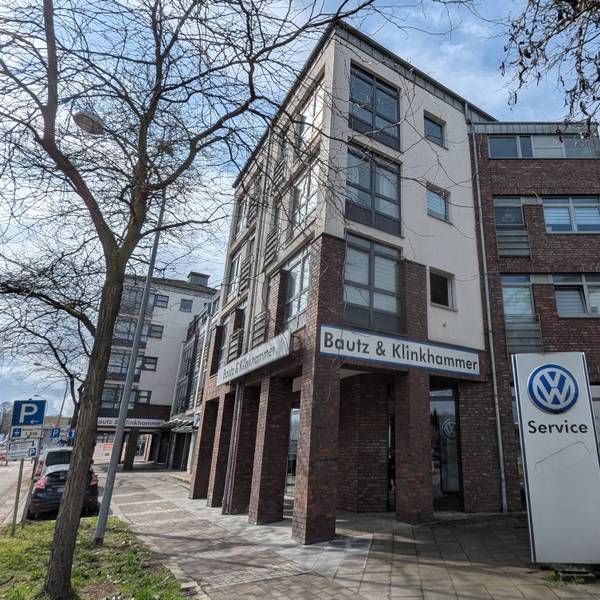 Das Foto zeigt das Wohn- und Geschäftshaus an der Luxemburger-, Ecke Bonnstraße, noch mit den alten Firmenschildern.
