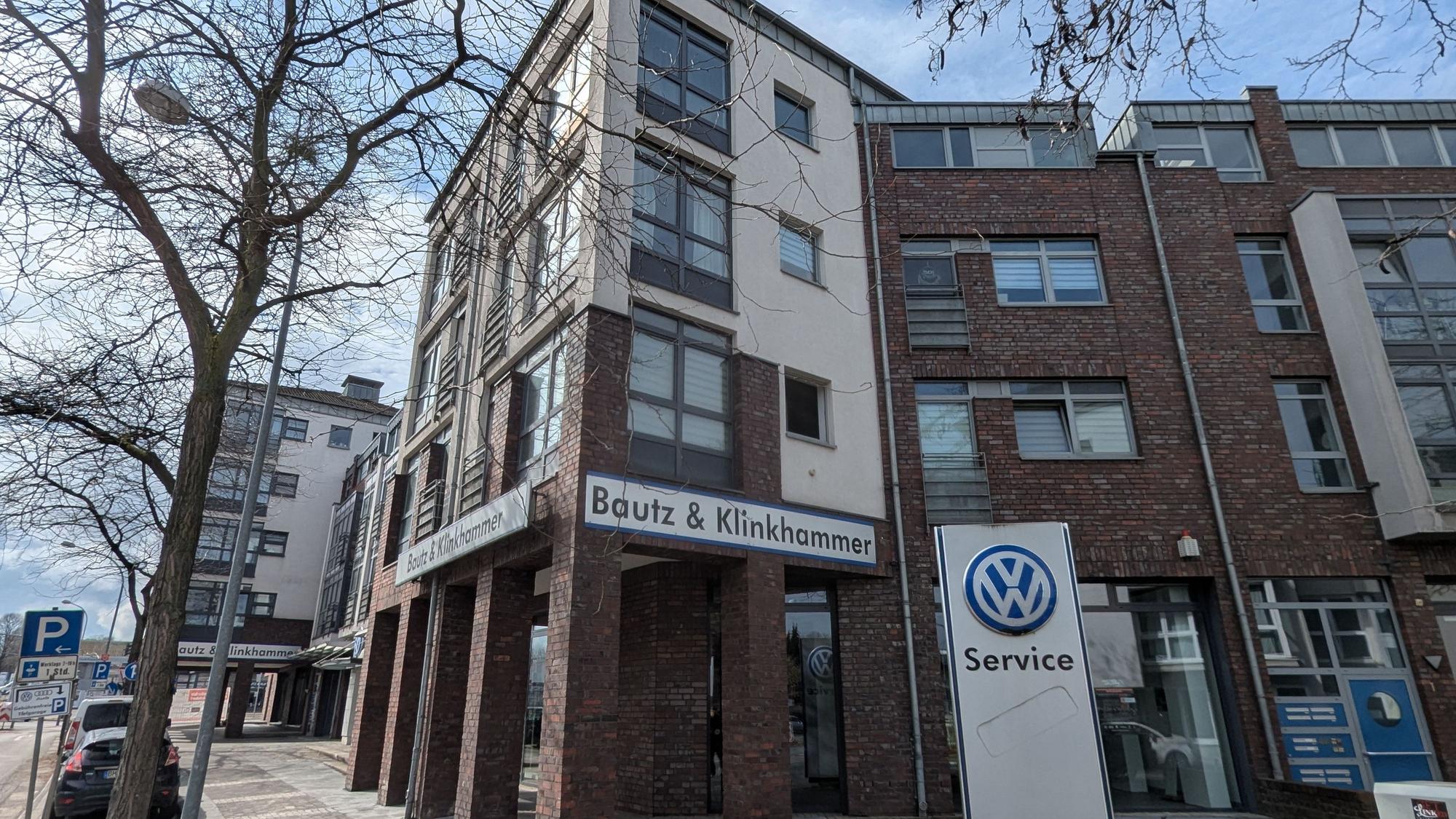 Das Foto zeigt das Wohn- und Geschäftshaus an der Luxemburger-, Ecke Bonnstraße, noch mit den alten Firmenschildern.