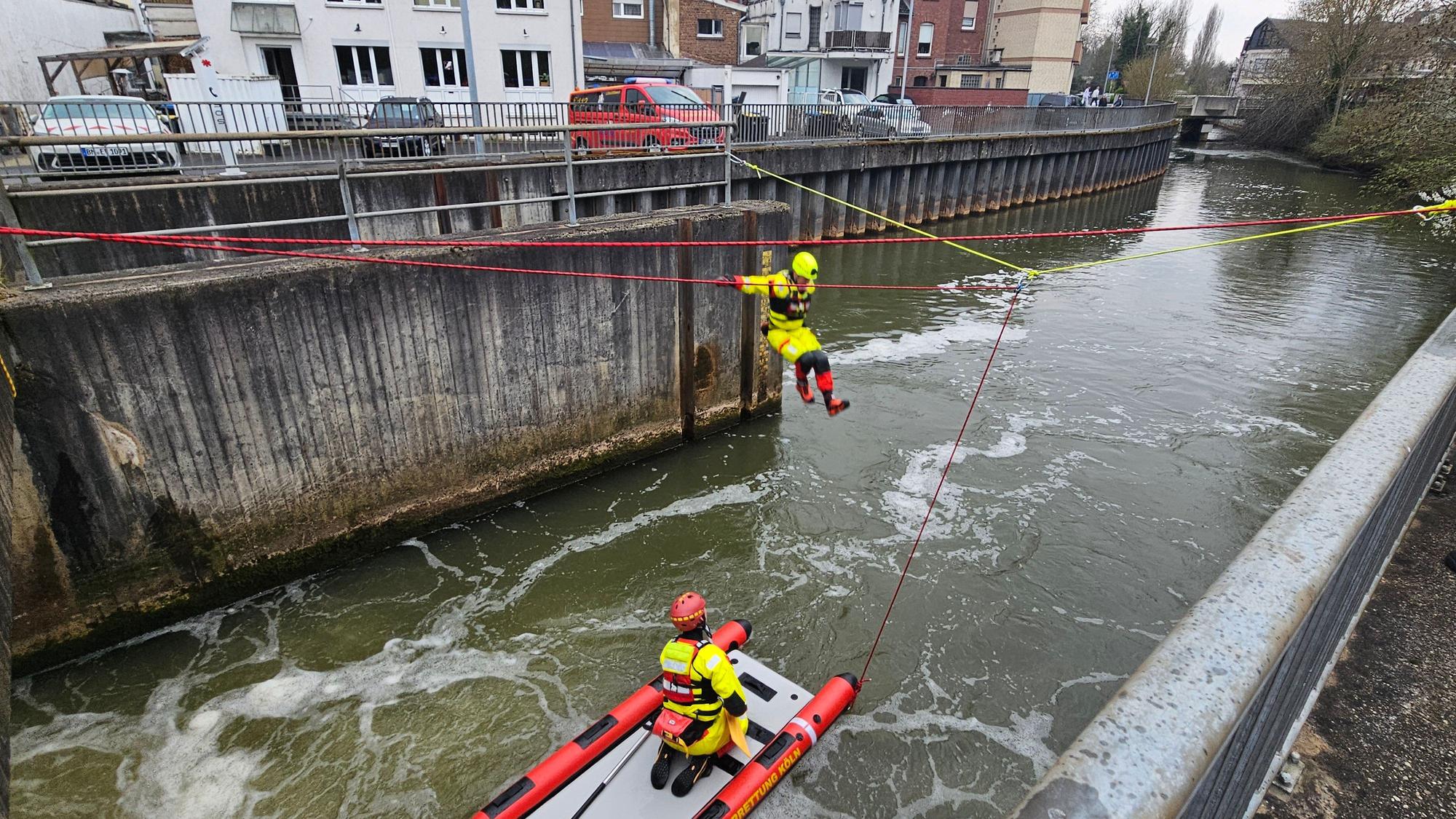 Zu sehen ist ein Strömungsretter der DLRG beim Sprung von einem Wehr in einen Fluss.