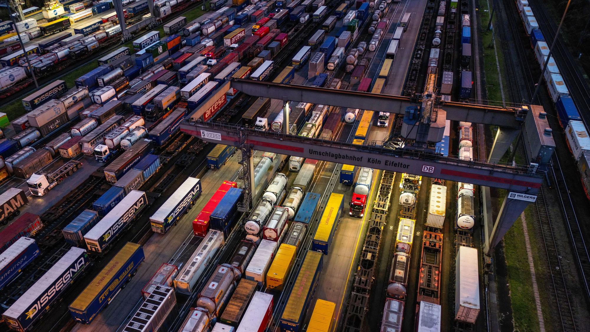 Container stehen im Umschlagbahnhof Köln Eifeltor auf Lkw und Güterzügen.