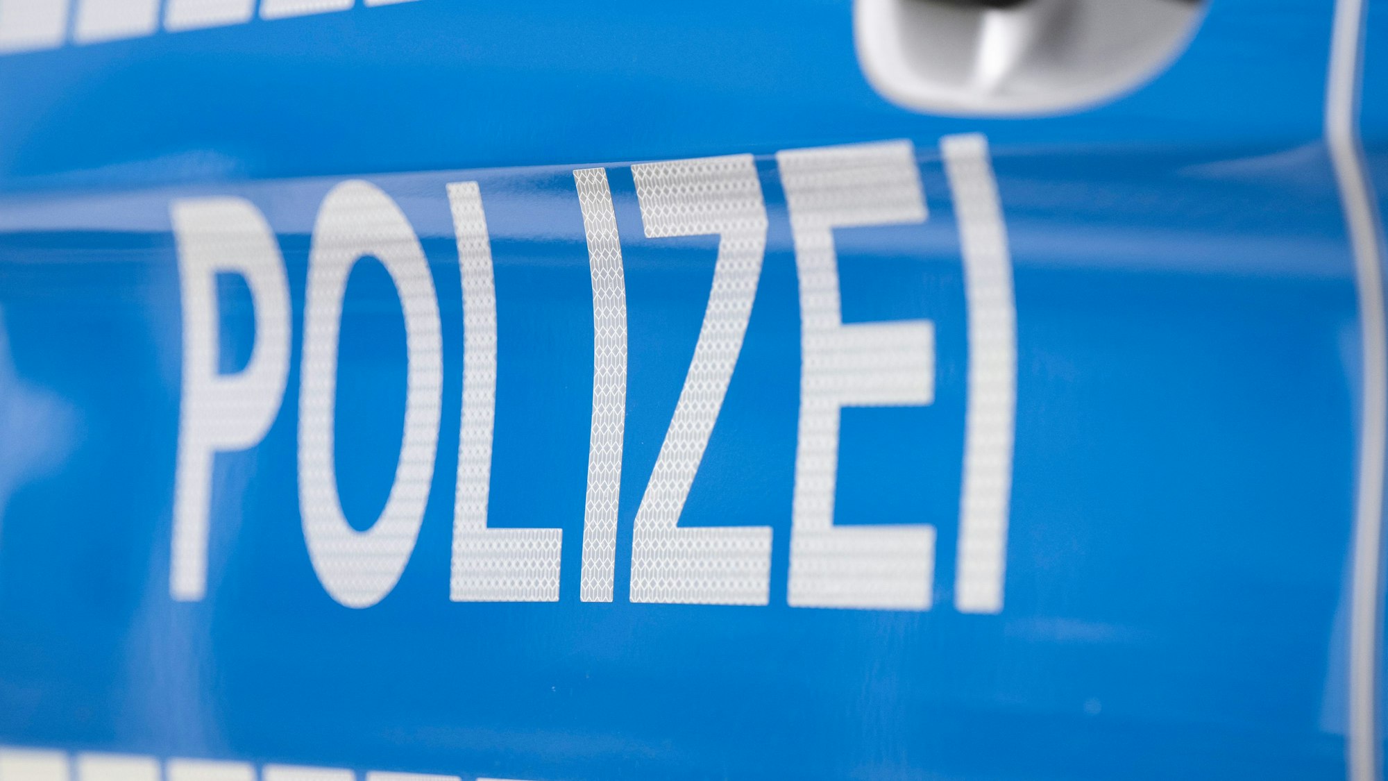 Das Foto zeigt den Schriftzug „Polizei“ auf einem Einsatzwagen.