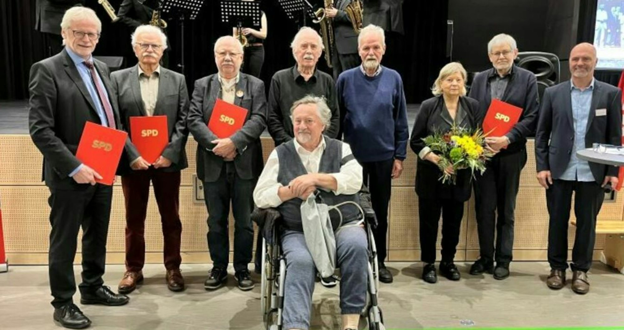 Zu sehen ist Willi Mengel, der im Rollstuhl sitzt. Hinter ihm stehen Parteifreunde.