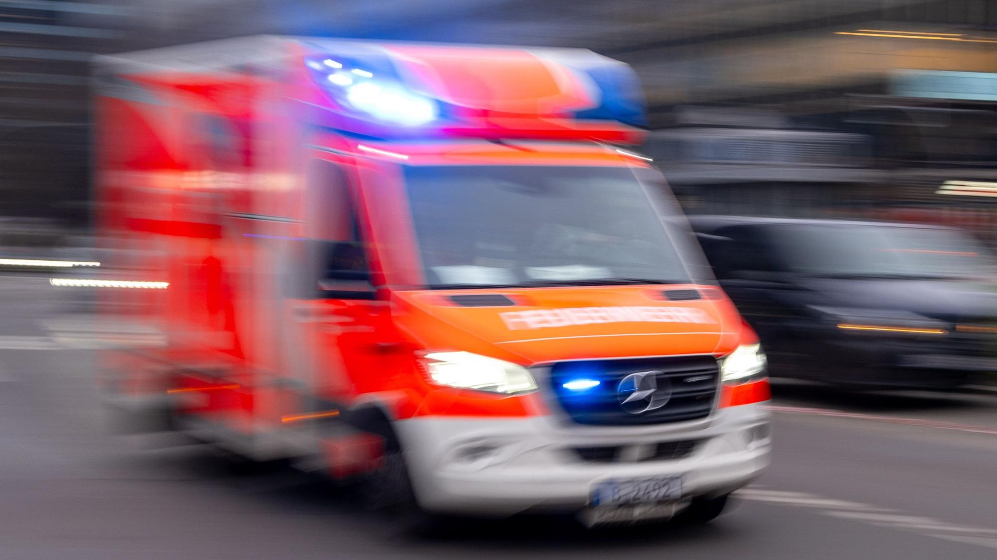 Ein Rettungswagen der Feuerwehr fährt mit Blaulicht zum Einsatz (Symbolbild)