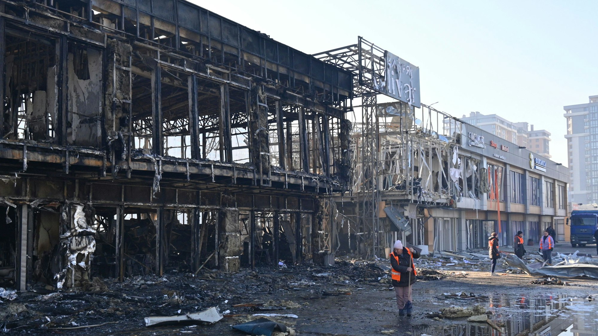 ARCHIV - 21.03.2025, Ukraine, Odessa: Städtische Arbeiter räumen auf, nachdem russische Drohnen während des nächtlichen Angriffs Geschäfte getroffen haben. (zu dpa: «Was die US-Gespräche mit Kiew und Moskau in Riad bringen») Foto: Michael Shtekel/AP/dpa +++ dpa-Bildfunk +++