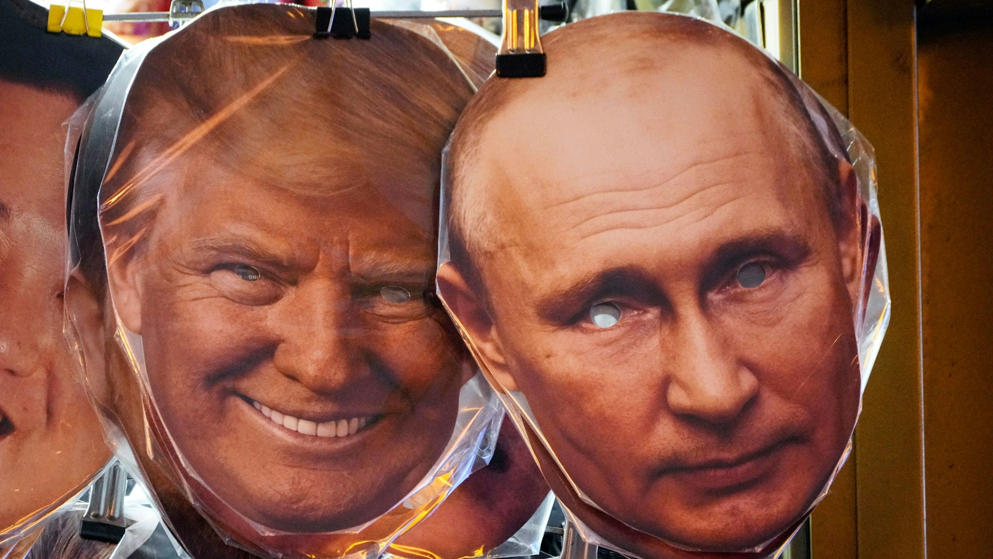 Gesichtsmasken, die Donald Trump und Wladimir Putin darstellen, hängen neben anderen in einem Souvenirladen in St. Petersburg.