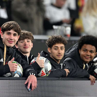 23.03.2025, Nordrhein-Westfalen, Dortmund: Fußball: Nations League A, Deutschland - Italien, Play-off-Runde, Viertelfinale, Rückspiele, Signal Iduna Park, Balljunge Noel Urbaniak (l) und weitere Balljungen sitzen hinter der Bande. Foto: Fabian Strauch/dpa +++ dpa-Bildfunk +++