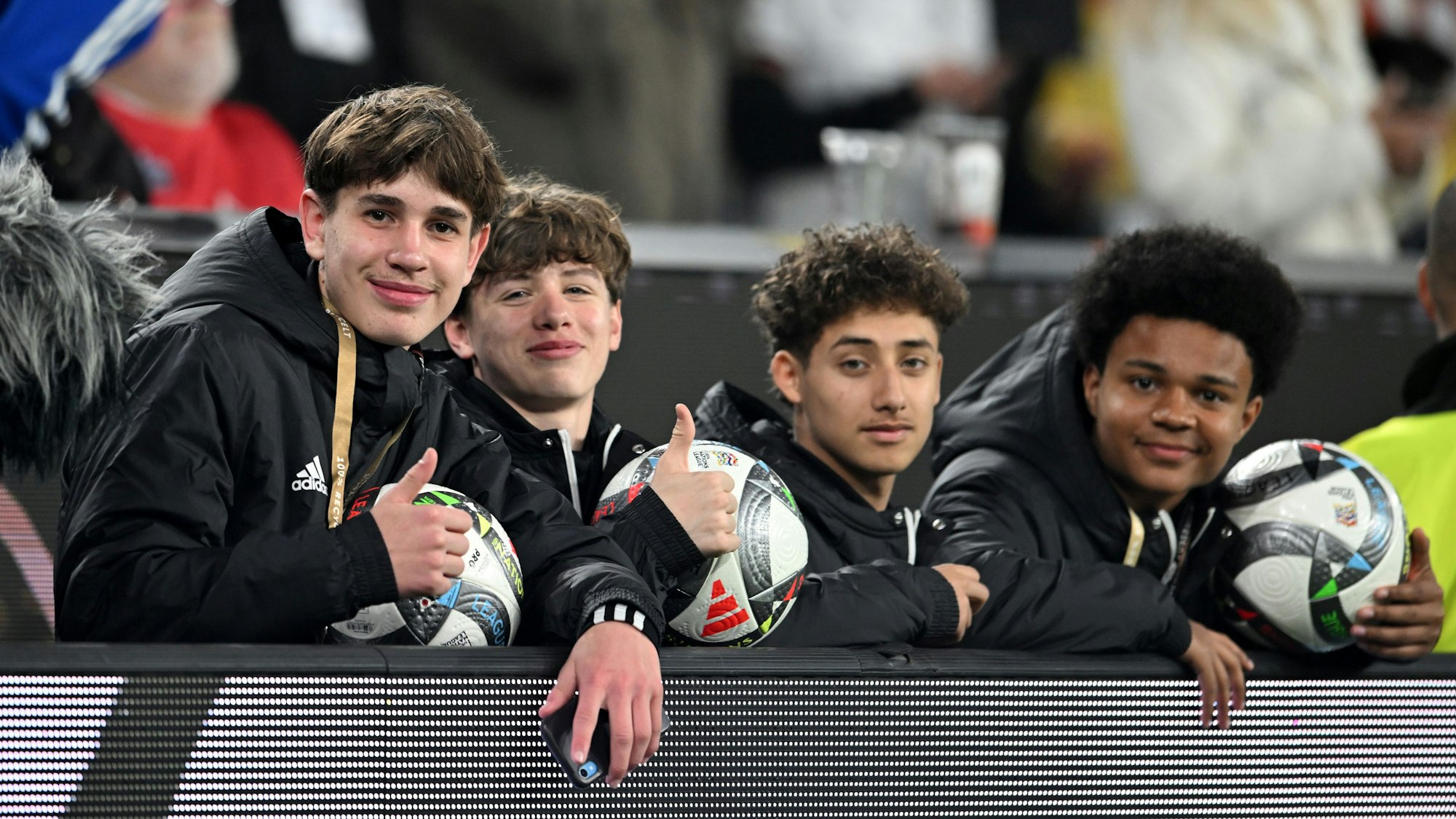 23.03.2025, Nordrhein-Westfalen, Dortmund: Fußball: Nations League A, Deutschland - Italien, Play-off-Runde, Viertelfinale, Rückspiele, Signal Iduna Park, Balljunge Noel Urbaniak (l) und weitere Balljungen sitzen hinter der Bande. Foto: Fabian Strauch/dpa +++ dpa-Bildfunk +++