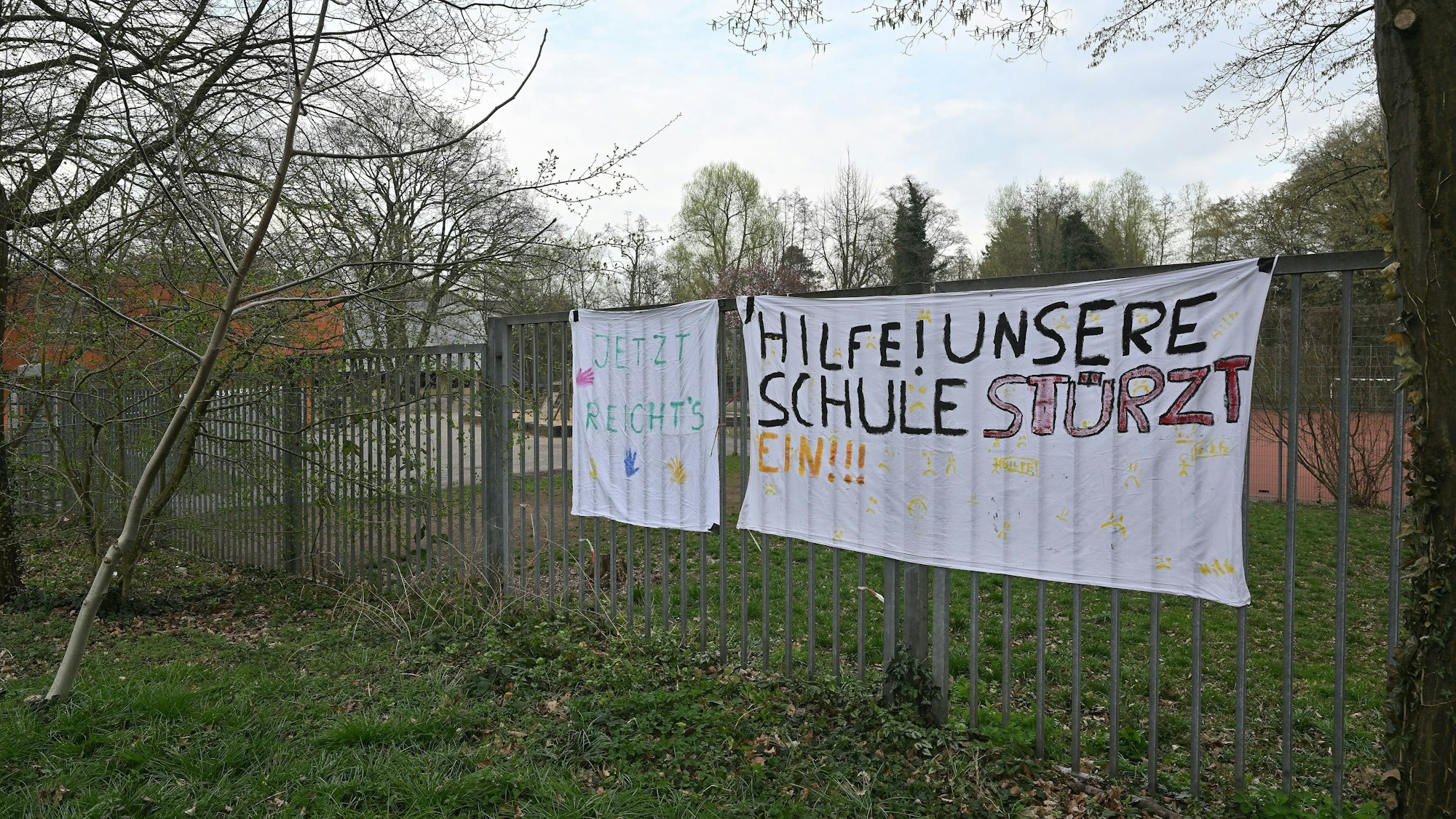 Auf dem Plakat steht: Hilfe! Unsere Schule stürzt ein.