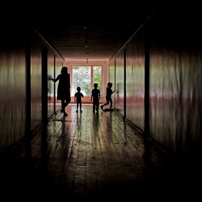 Eine Frau steht mit drei Kindern in einem Flur in einer Zufluchtsstätte für Minderjährige in der Ukraine. (Archivbild)