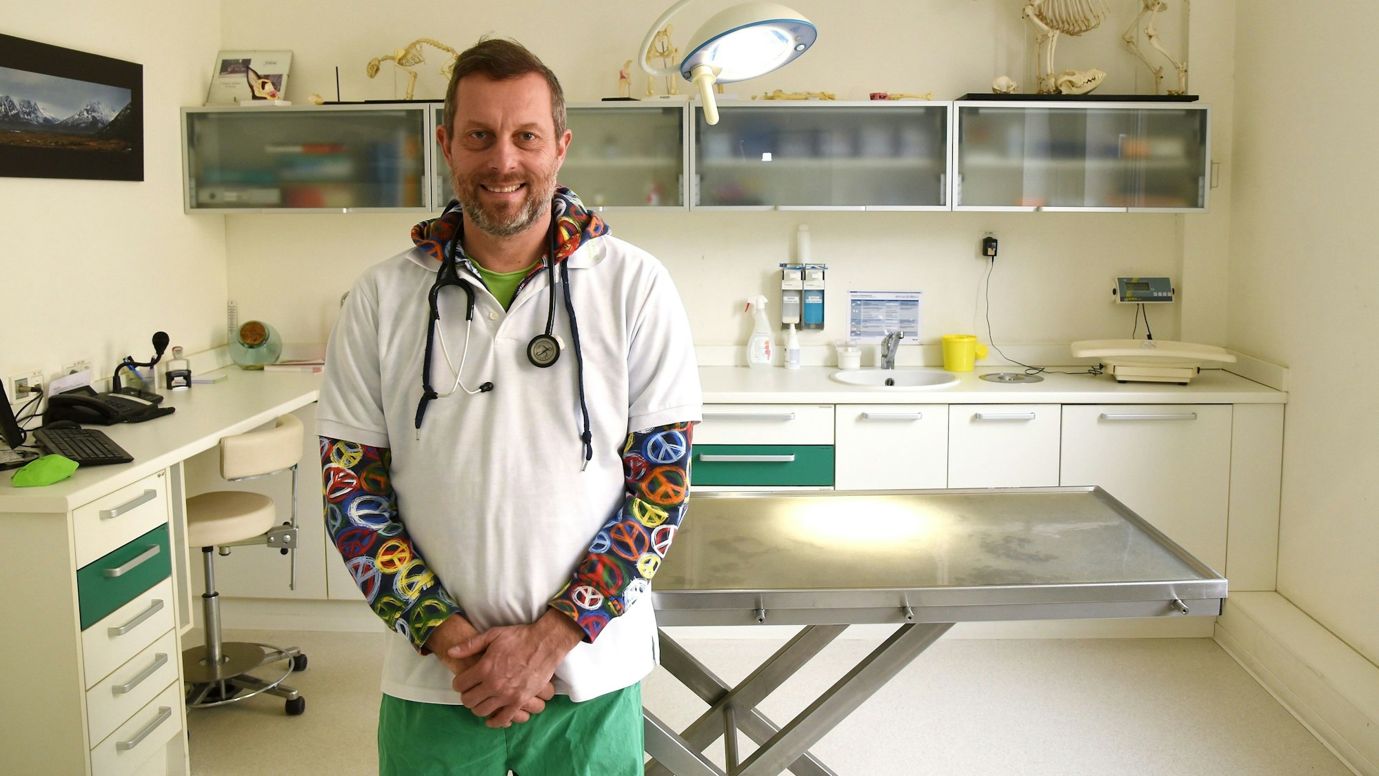 In einem Behandlungszimmer einer Tierarztpraxis steht Tierarzt Ralf Unna.