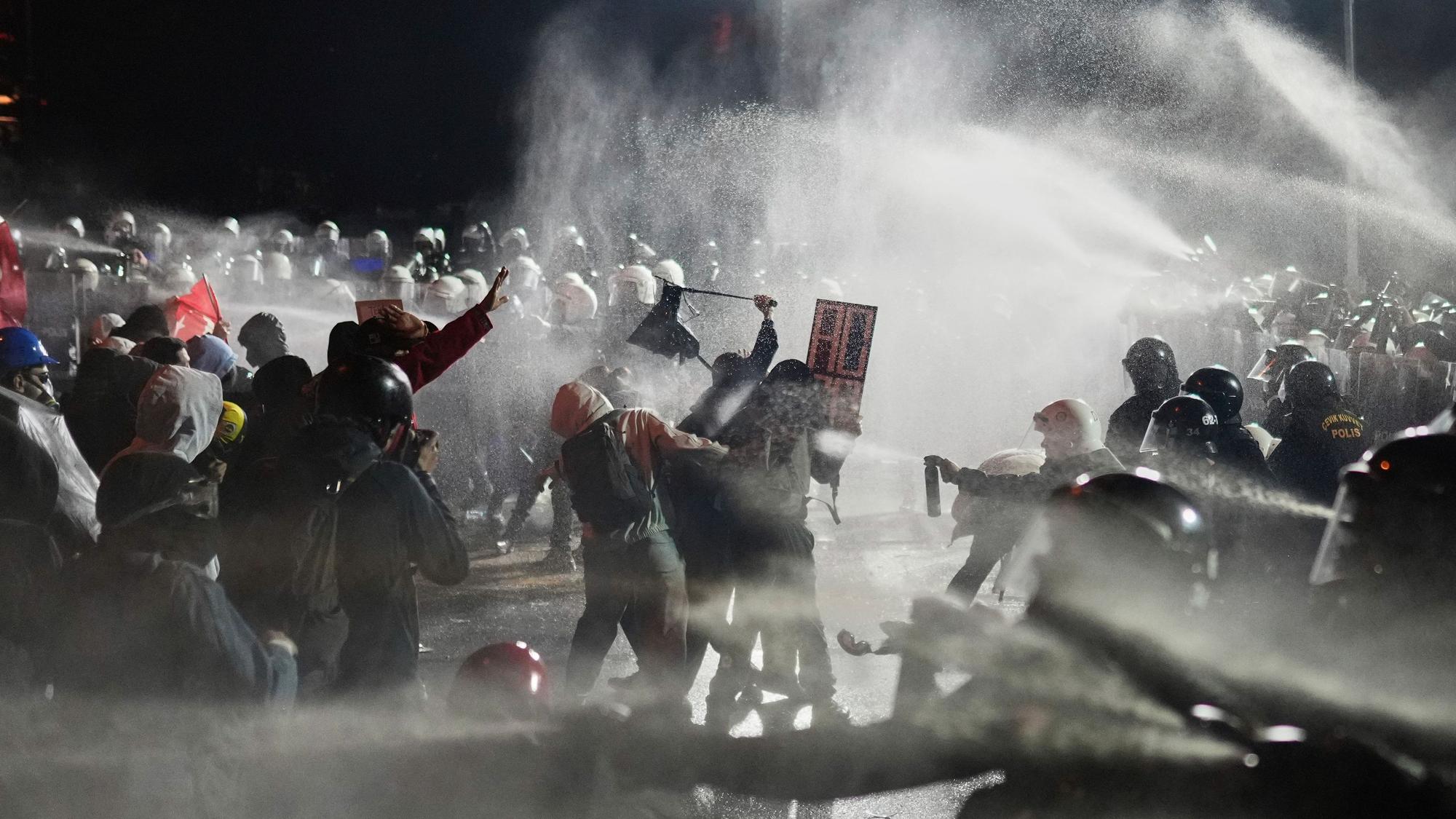 23.03.2025, Türkei, Istanbul: Beamte der Bereitschaftspolizei stoßen mit Demonstranten zusammen.