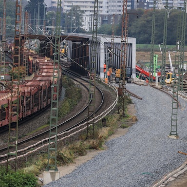 Ein Güterzug passiert eine Baustelle mit einem Schotterbett für neue Gleise. Die Strecke Emmerich-Oberhausen ist eine wichtige Verbindung für den Güterverkehr vom großen Überseehafen Rotterdam bis nach Genua. Sie wird für den europäischen Güterverkehr ausgebaut.