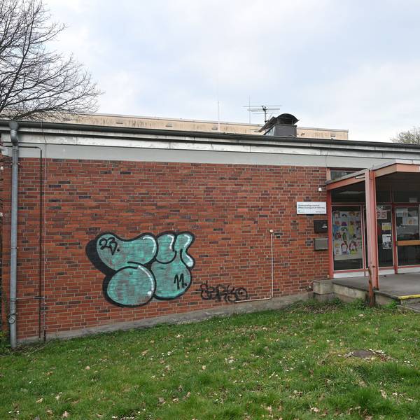 Man sieht den Eingang des einstöckigen Schulgebäudes.