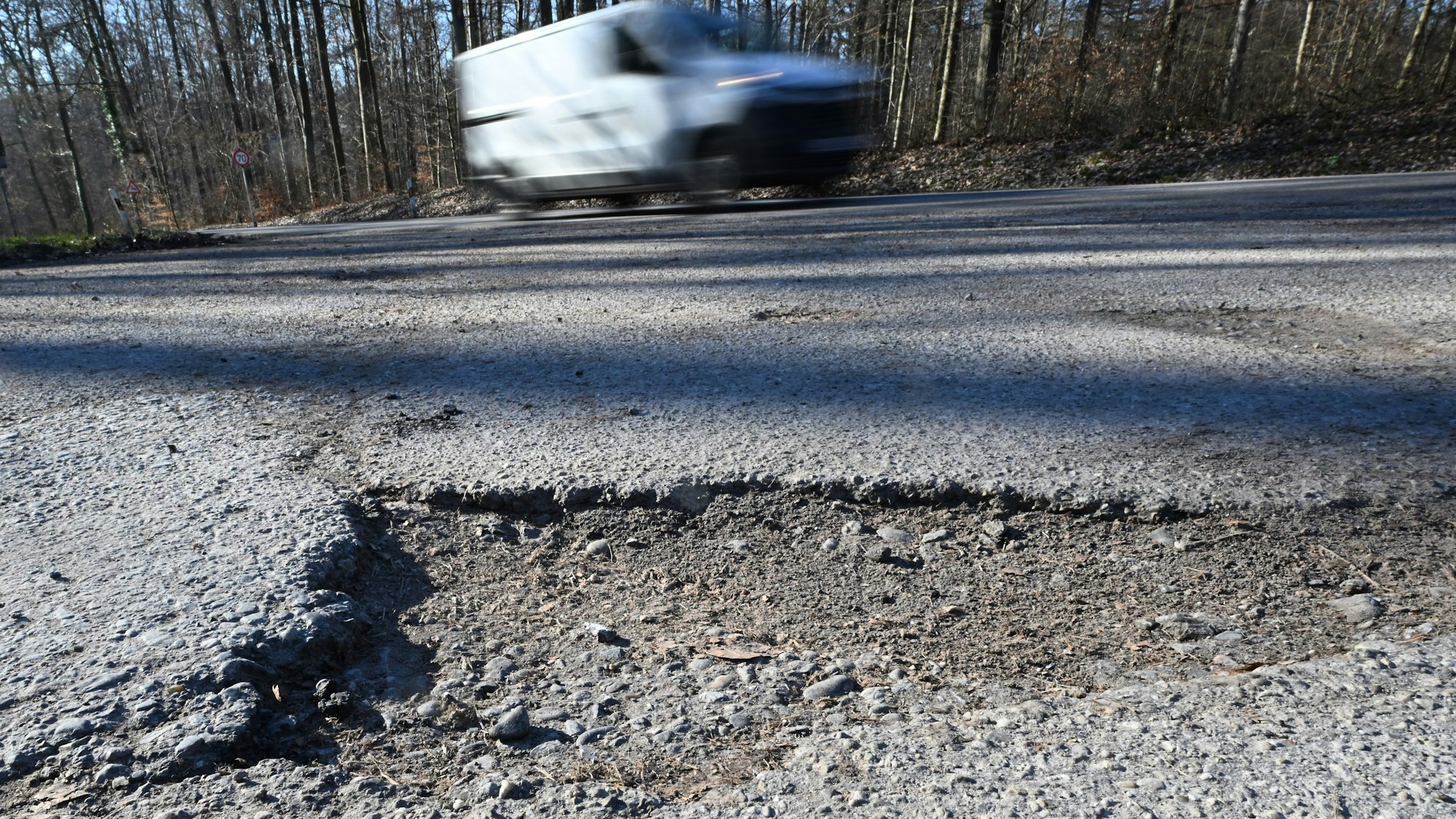 Schäden auf einem Weg an einer Landstraße.