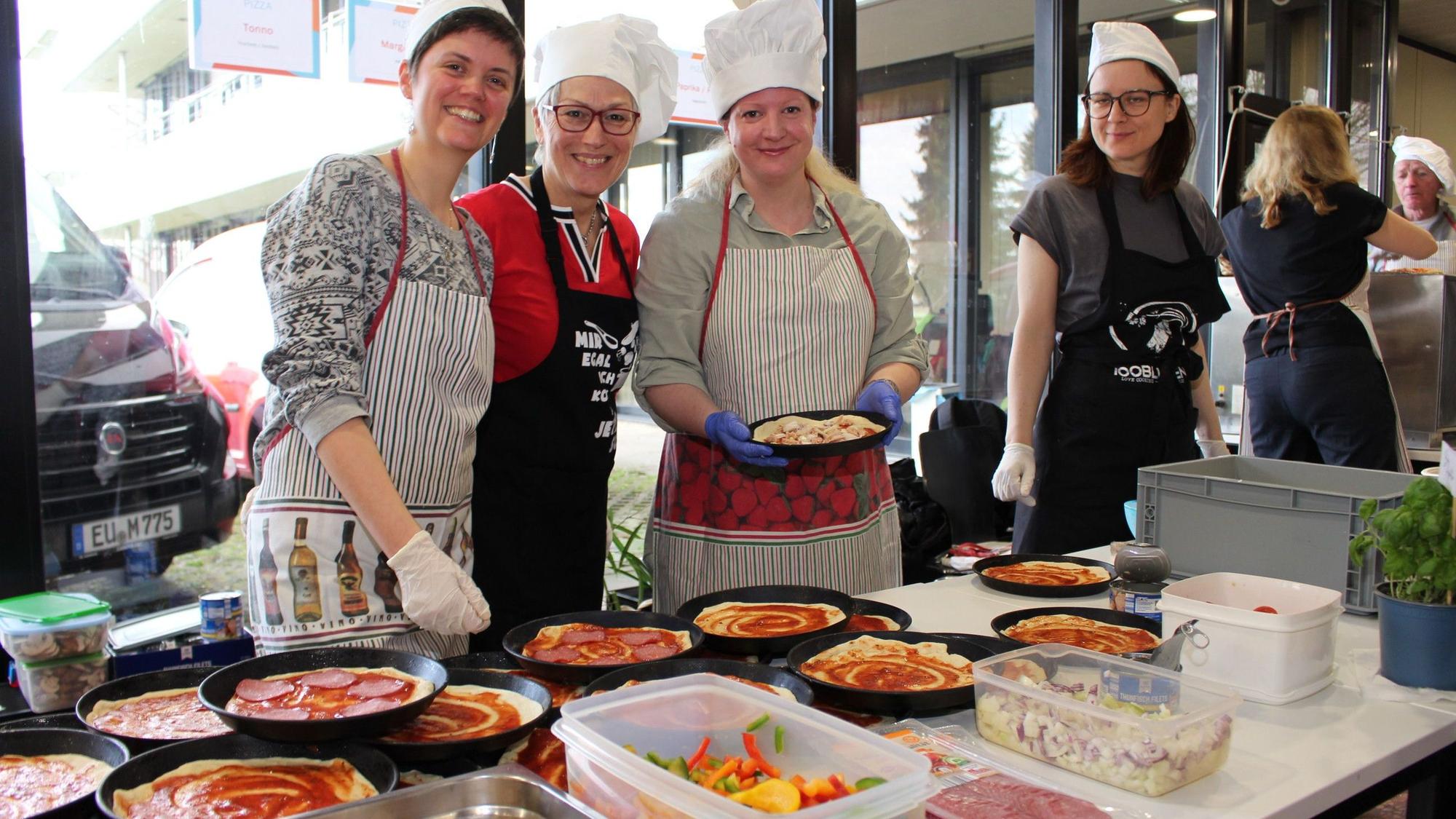Mitarbeiterinnen der Kreisverwaltung belegen Pizzen.