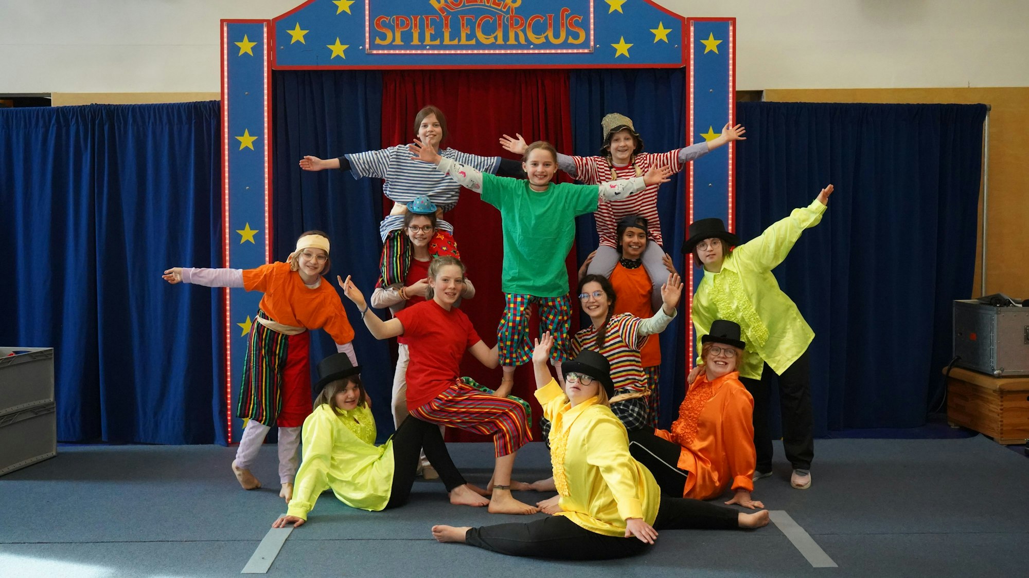 Kinder in Kostümen posieren in der Manege des Spielecircus.