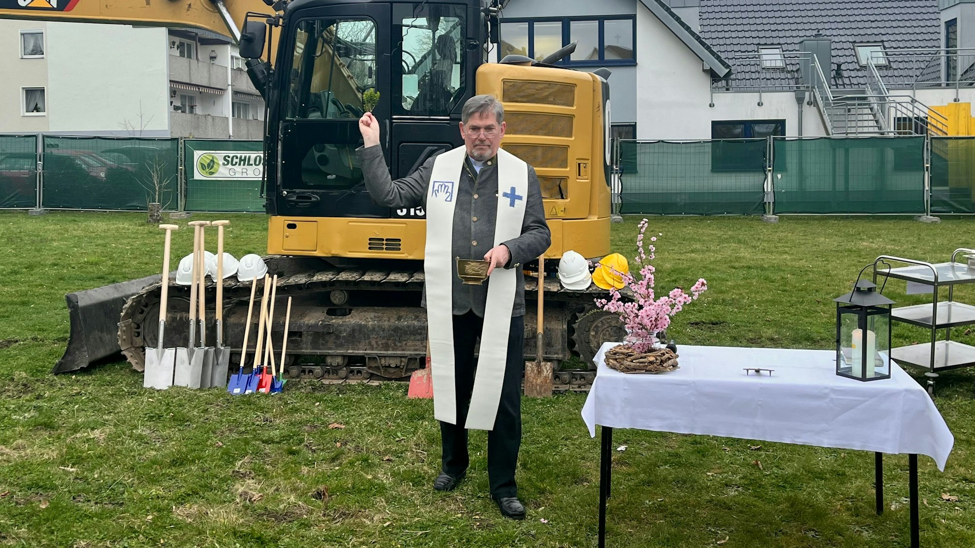 Spatenstich zum Neubau Haus Nazareth: Ein Pfarrer segnet die Baustelle.