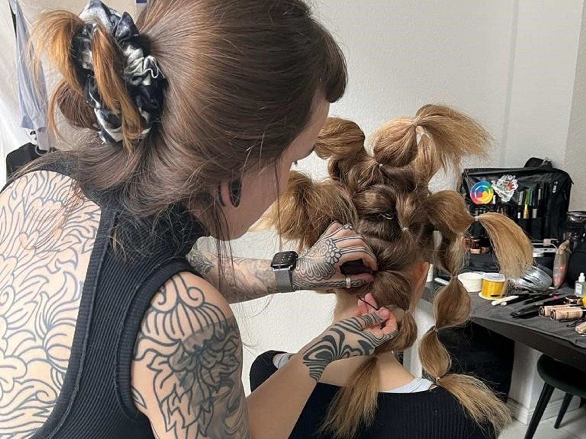 Laura Gertz arbeitet an einer kunstvollen Frisur ihres Models.