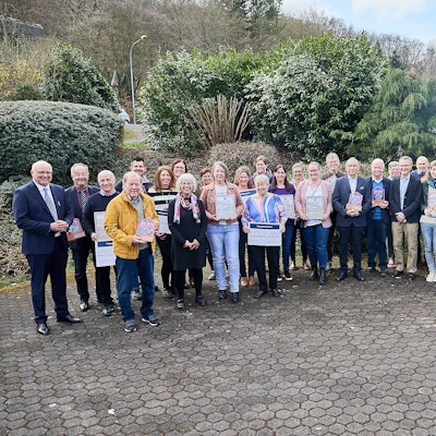 Die Träger des Heimatpreises 2025 der Stadt Heimbach stehen in einem Halbkreis auf einem Hof.