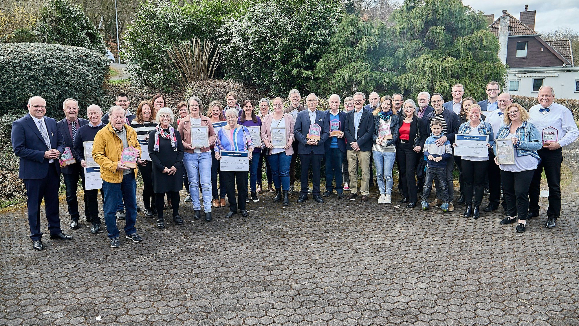 Die Träger des Heimatpreises 2025 der Stadt Heimbach stehen in einem Halbkreis auf einem Hof.