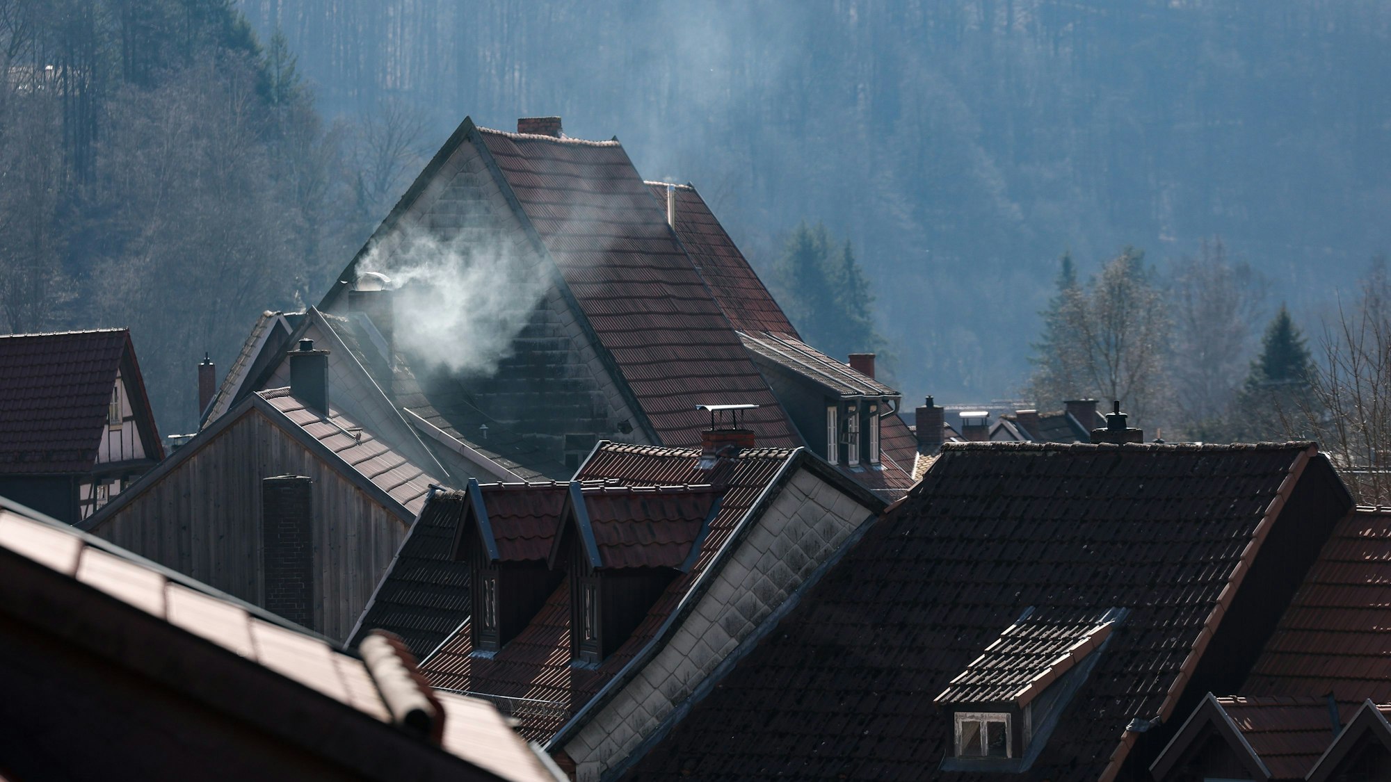20.03.2025, Sachsen-Anhalt, Stolberg/Harz: Eine Schornstein qualmt über den Dächern des Fachwerkstädtchens im Südharz. Dem Deutschen Wetterdienst zu Folge werden die Nachtfröste in den kommenden Nächten deutlich abnehmen. Foto: Jan Woitas/dpa +++ dpa-Bildfunk +++
