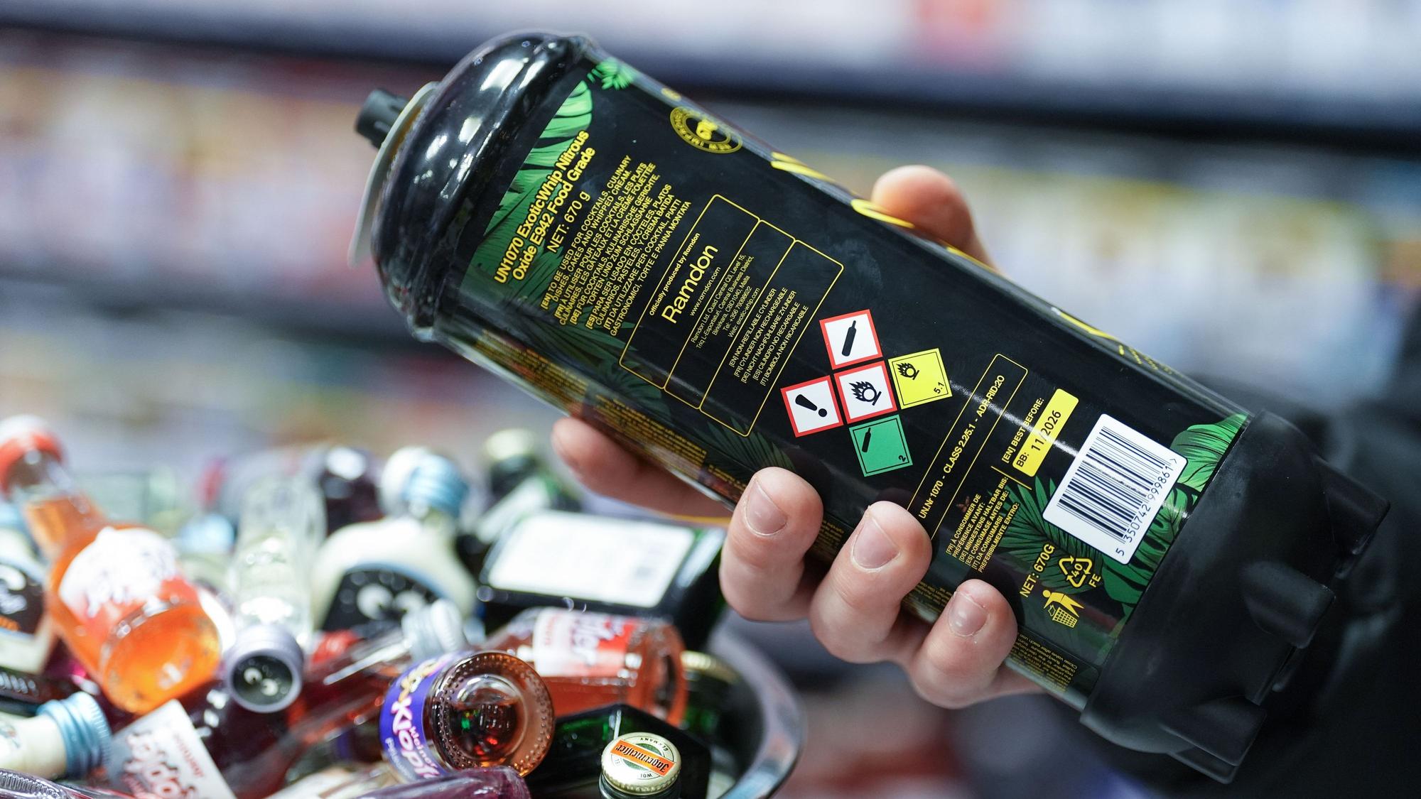 Ein Mitarbeiter hält eine Dose Lachgas am Tresen eines Kiosks in der Hand: In Bad Honnef wird jetzt ein Verkaufsverbot an Minderjährige geprüft.