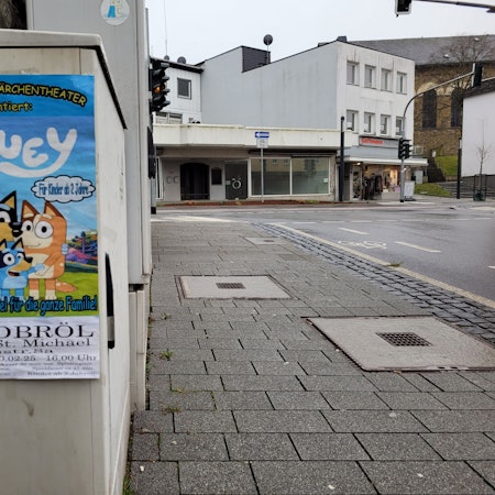 Ein Plakat an einem Stromkasten wirbt für eine Puppentheateraufführung.
