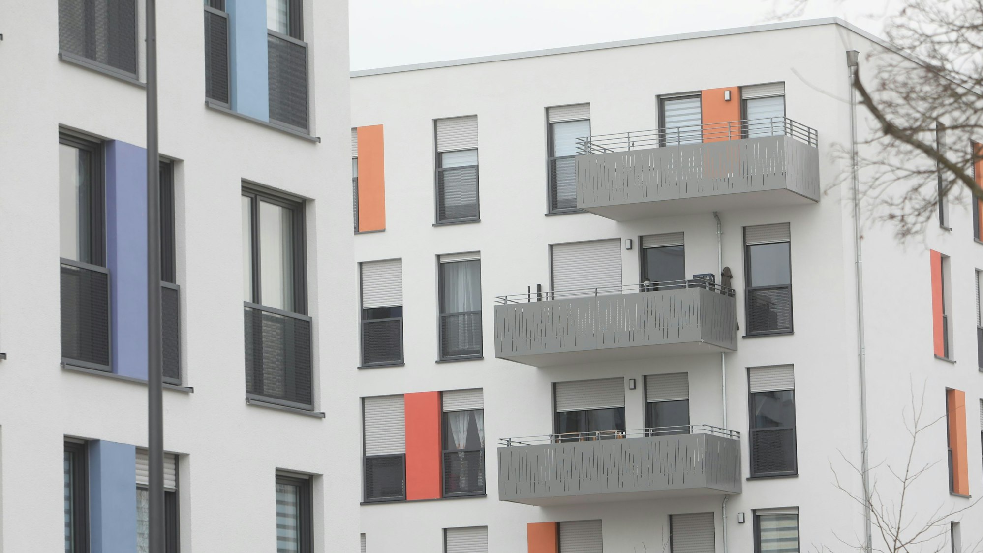 Zu sehen sind weiße Häuserfassaden mit Balkonen.