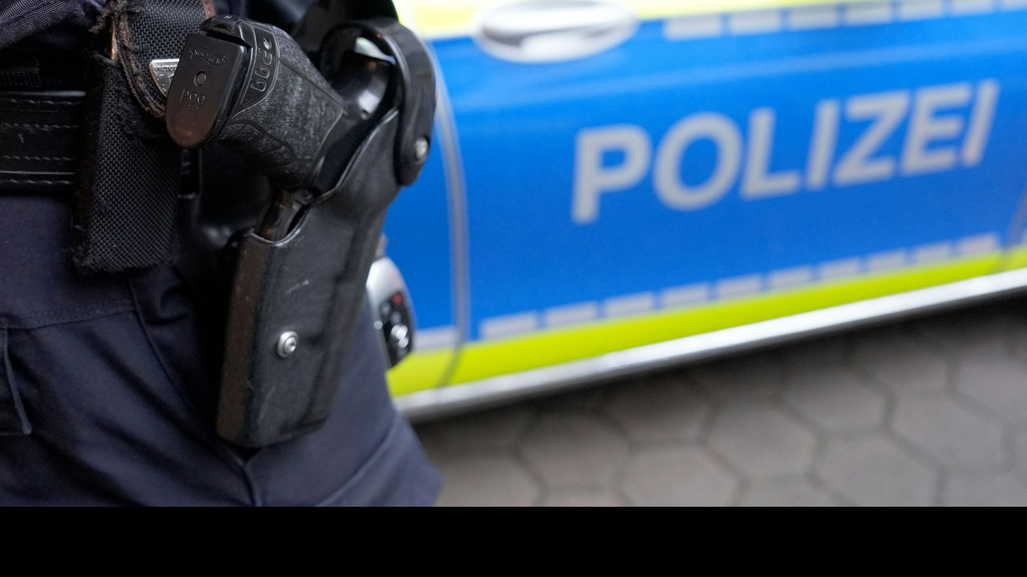 Ein Polizist mit einer Waffe im Holster (Symbolfoto)