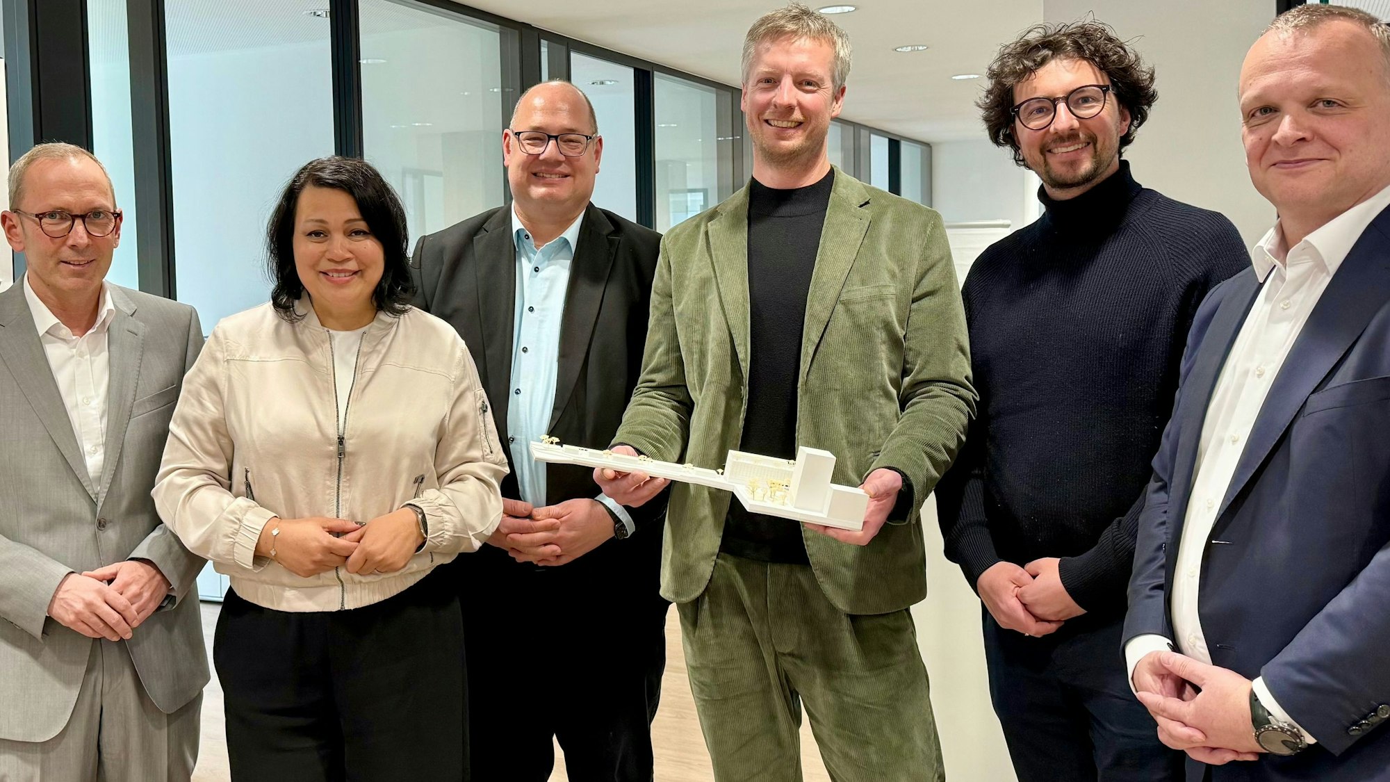 WfL-Chef Markus Maertens, die SWM-Aufseher Milanie Kreutz und Stefan Hebbel, die Architekten Jan Busemeyer und René Rheims mit SWM-Geschäftsführer Björn Krischick und einem Modell des Entwurfs