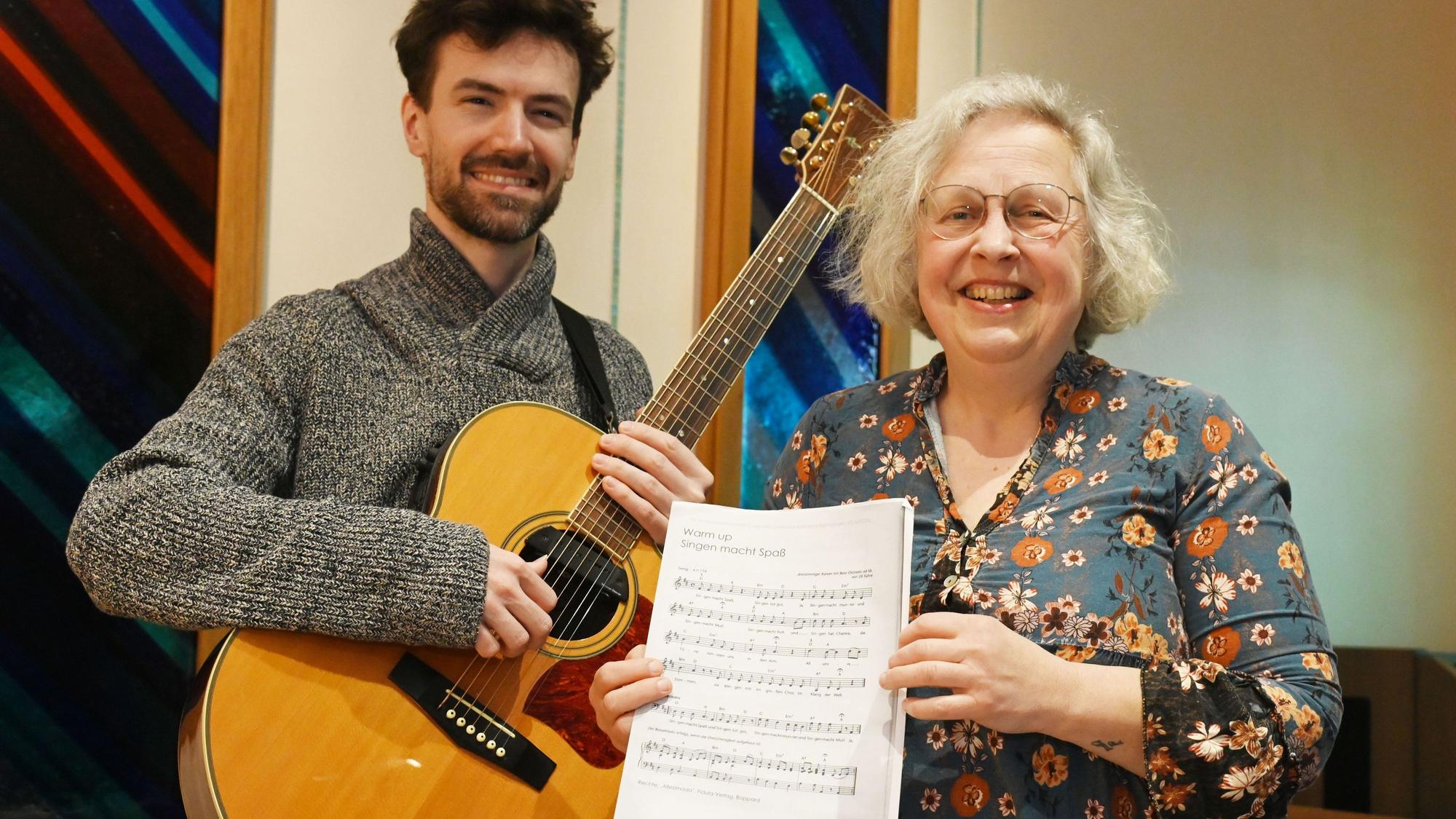 19.03.2025 Köln. COPD, Asthma, chronische Bronchitis, Lungenkrebs, transplantierte Lunge - im Chor Pneumissimo können auch diese Menschen singen. Wie das Singen lungenerkrankten Menschen sogar helfen kann (Besuch einer Chorprobe, Chor feiert im April Zehnjähriges). Ian Alexander Griffiths (li.) und Chorleiterin Anette Einzmann. Foto: Alexander Schwaiger