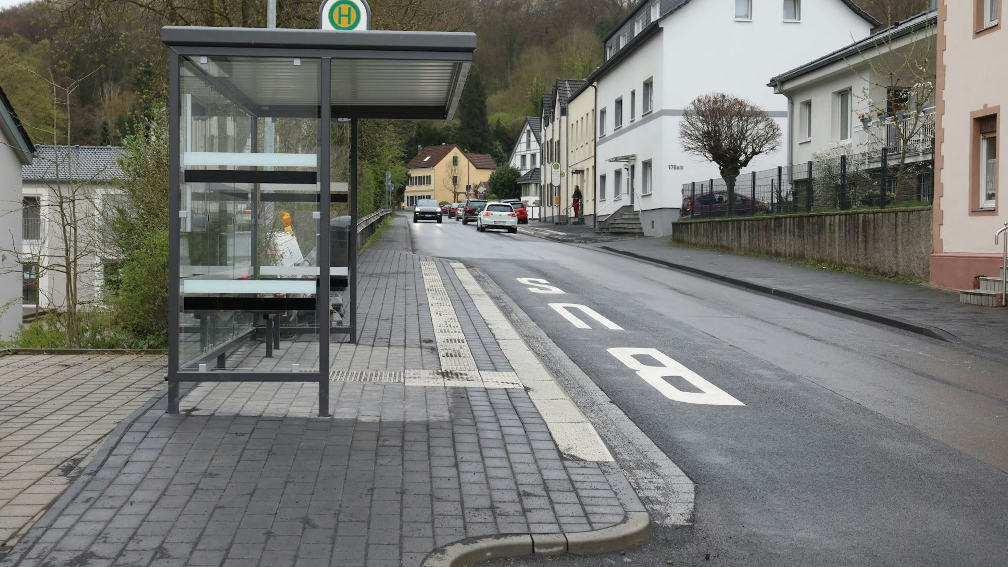 Eine Bushaltestelle mit Wartehäuschen, auf der Fahrbahn ist das Wort Bus angebracht.