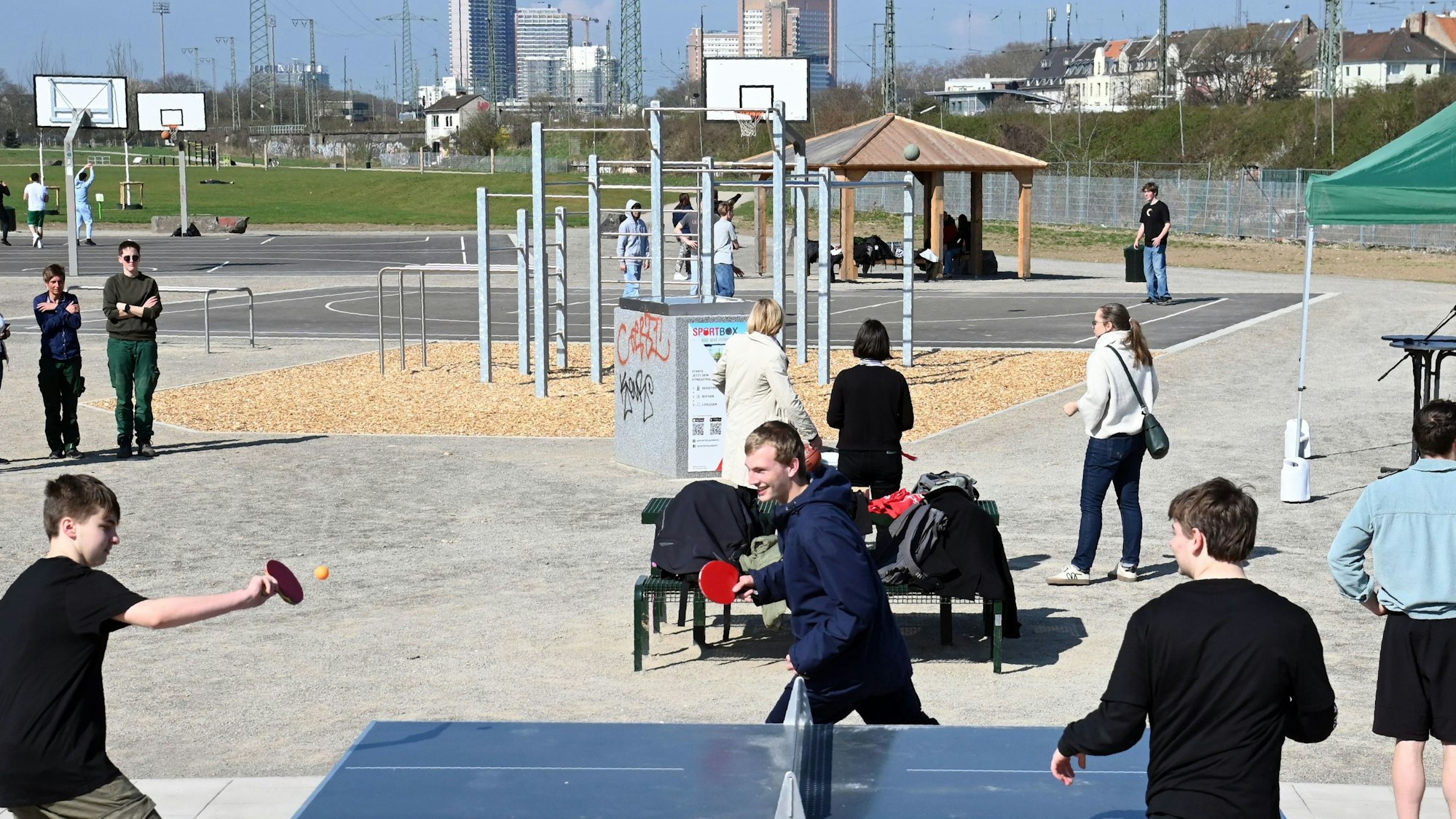 Drei Jugendliche spielen Tischtennis.