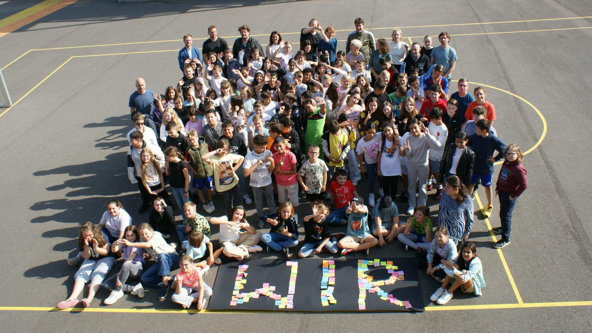 108 Mädchen und Jungen aus der Gründungs-Jahrgangsstufe 5 mit dem Kollegium und den Beschäftigten der Schule.