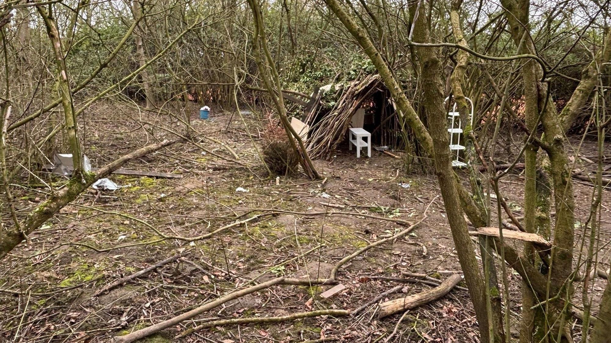 Auf dem Bild ist ein Teil des Grundstücks zu sehen, auf dem ein Tipi gebaut ist und Müll herum liegt.