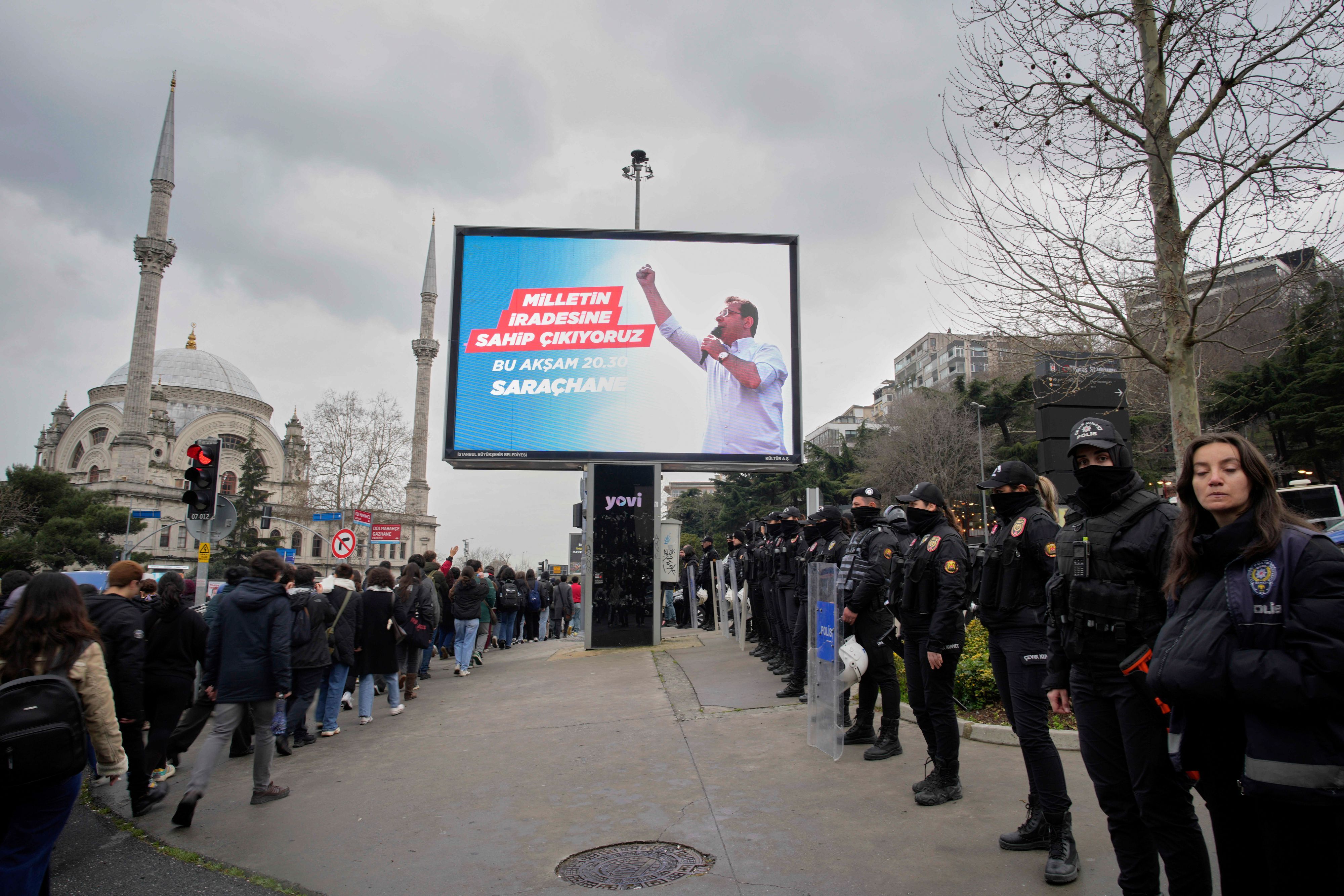 Studenten (l) marschieren an einem Bildschirm mit dem Bild des Istanbuler Bürgermeisters Ekrem Imamoglu vorbei, um gegen seine Verhaftung zu protestieren. (Archivbild)