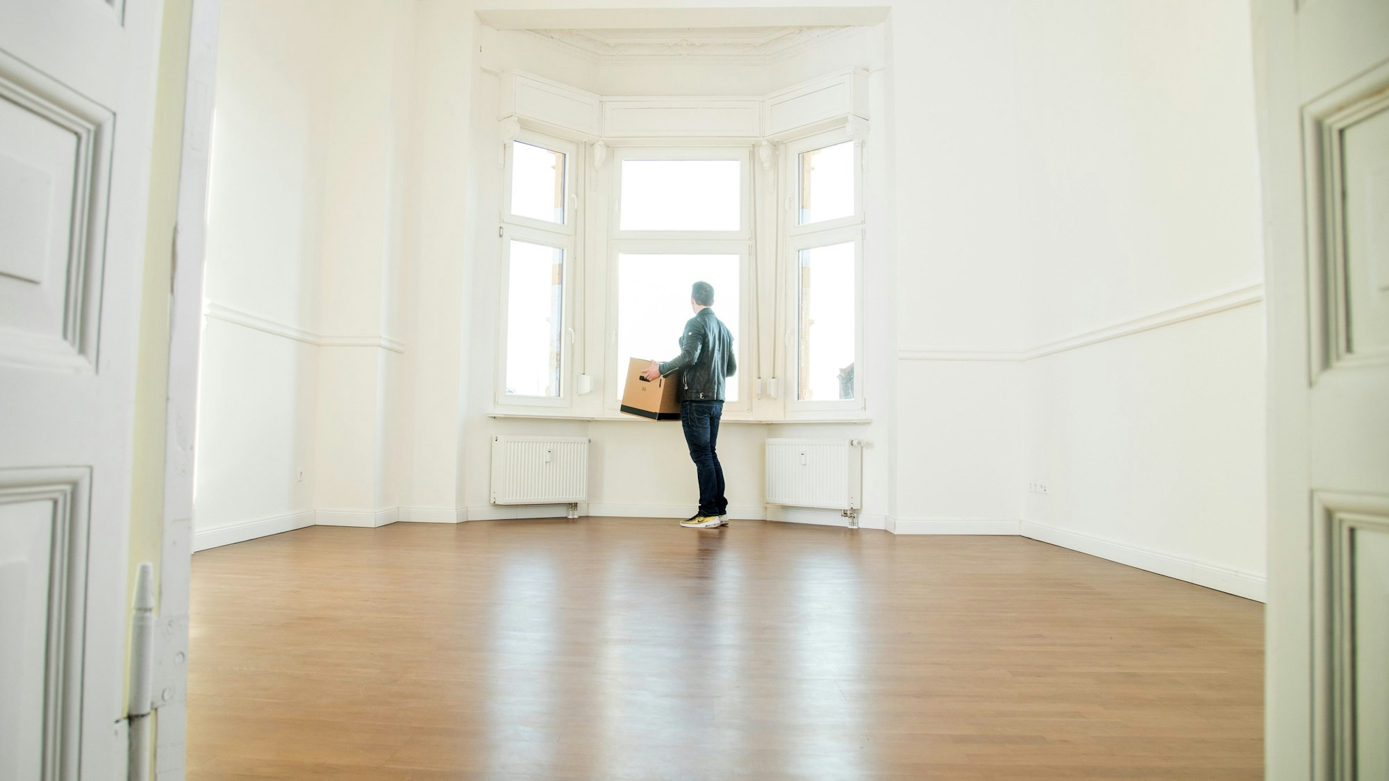 Das Symbolbild zeigte eine Person, die einen Karton in leere Wohnung trägt.