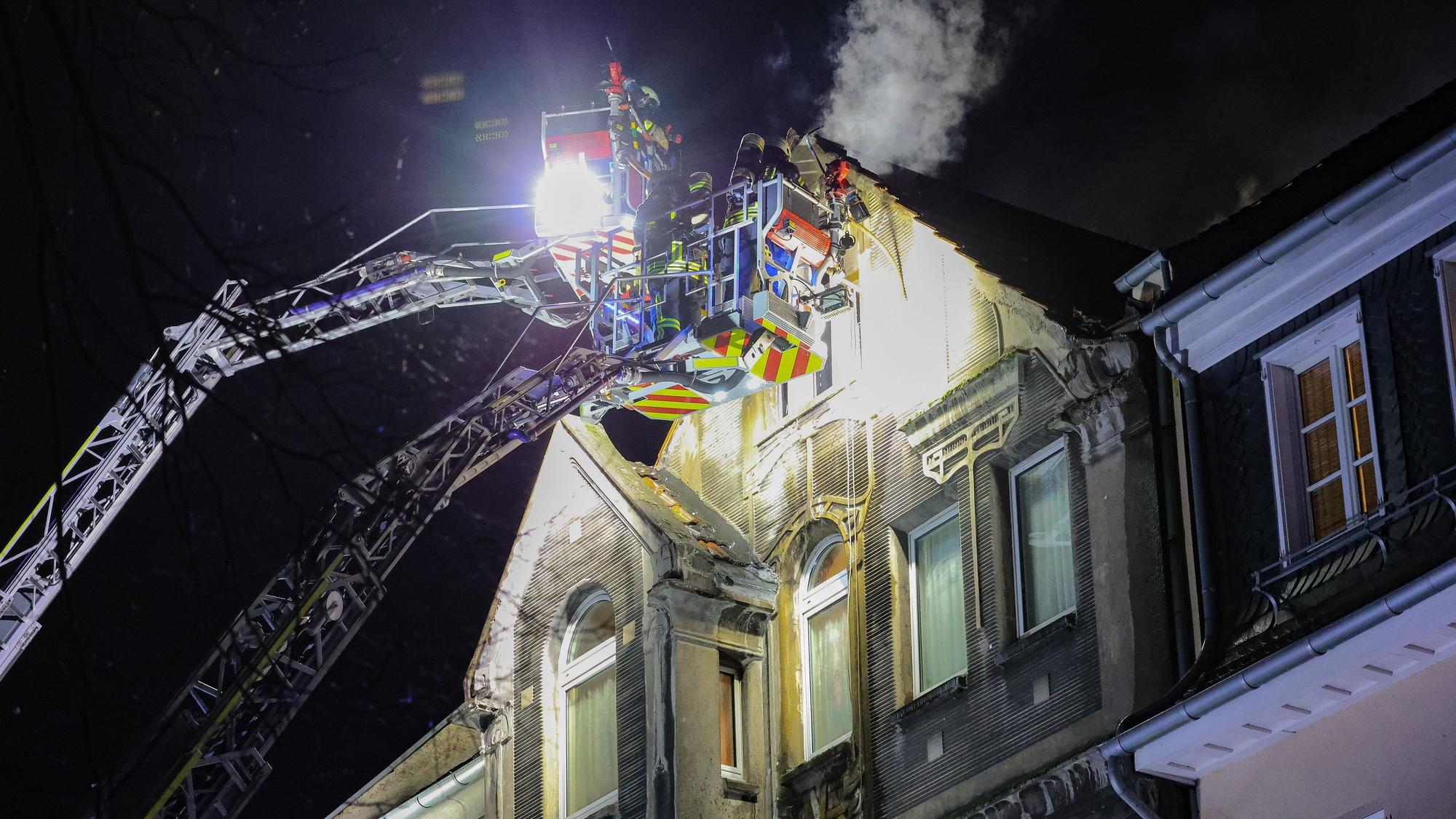 27.03.2025, Nordrhein-Westfalen, Leverkusen: Feuerwehrleute arbeiten mit zwei Drehleitern an einem Brand. Bei einem Wohnungsbrand in Leverkusen sind Menschen ums Leben gekommen. Vor Ort stellten die Feuerwehr dichten Rauch im dritten Obergeschoss des Hauses fest. Foto: Gianni Gattus/dpa +++ dpa-Bildfunk +++