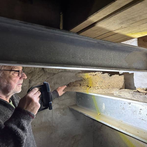 Manfred Bethge im Glockenturm von Sankt Servatius in Siegburg. Er leuchtet von Holzwürmern zerfressene Balkenstücke an, die ausgetauscht wurden. Stahlträger und neue Eichenbalken ersetzen sie jetzt.